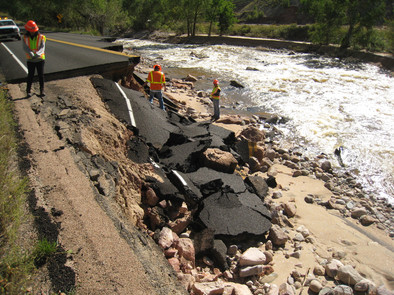 FILE PHOTO: Colorado Department of Transportation workers inspect road damage from the 2013 flood in St. Vrain Canyon, Colo. (Courtesy of Colorado Department of Transportation)