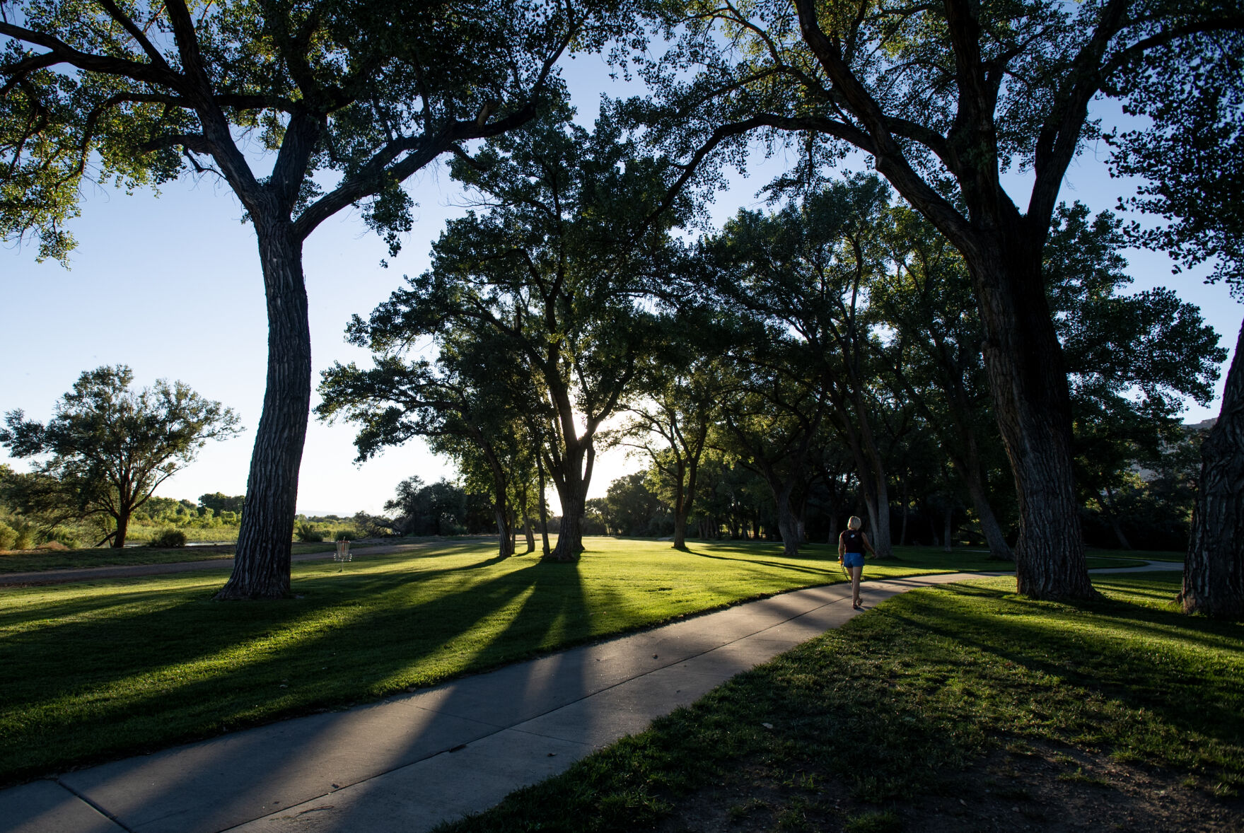 A pedestrian walks along the Colorado Riverfront Trail where it passes through Riverbend Park in Palisade, Colo., on Tuesday, Aug. 29, 2023. (Parker Seibold)