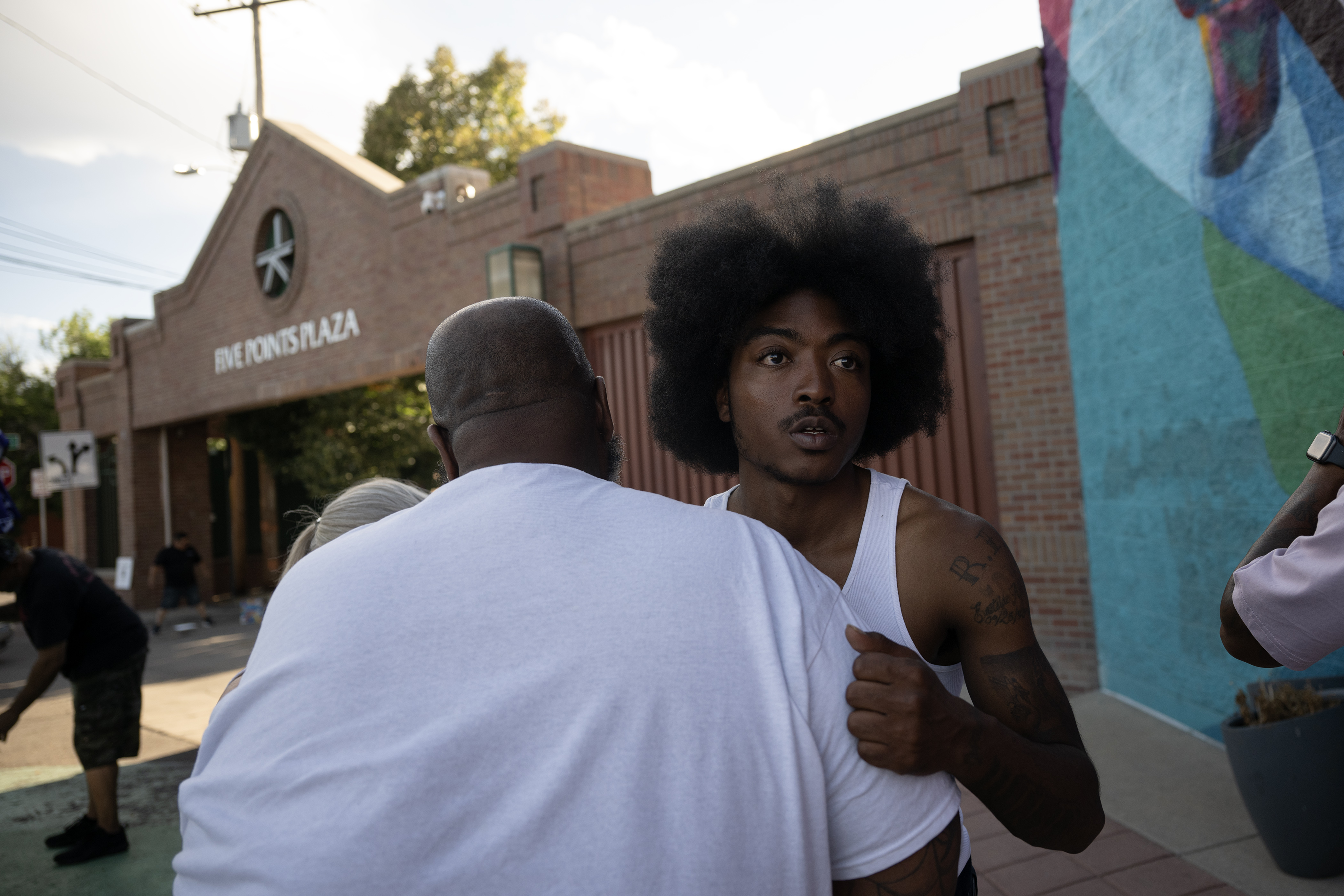 Struggle of Love Foundation secondary youth violence prevention specialist Jason McBride, left, hugs Qtee, a childhood friend of a shooting victim who was killed a block away on Aug. 19, during a “Safe Haven Activation” in response to the shooting double-homicide on Aug. 19 as seen on Thursday, Aug. 31, 2023, at Five Points Plaza in Denver. (Timothy Hurst/Denver Gazette) (TimHursttim.hurst@gazette.comhttps://secure.gravatar.com/avatar/aca82bd62b4ee425c598527cd6faa1b1?d=mm&r=g)