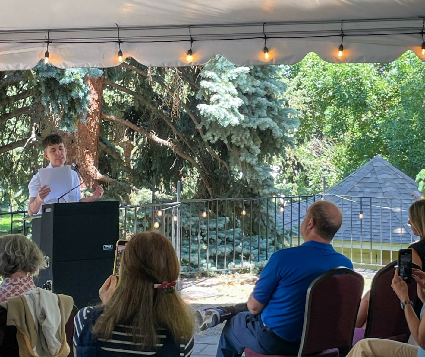 New Colorado Poet Laureate Andrea Gibson reads to the gathered audience that includes Gov. Jared Polis, right, at the Colorado Chautauqua in Boulder on Sept. 6.