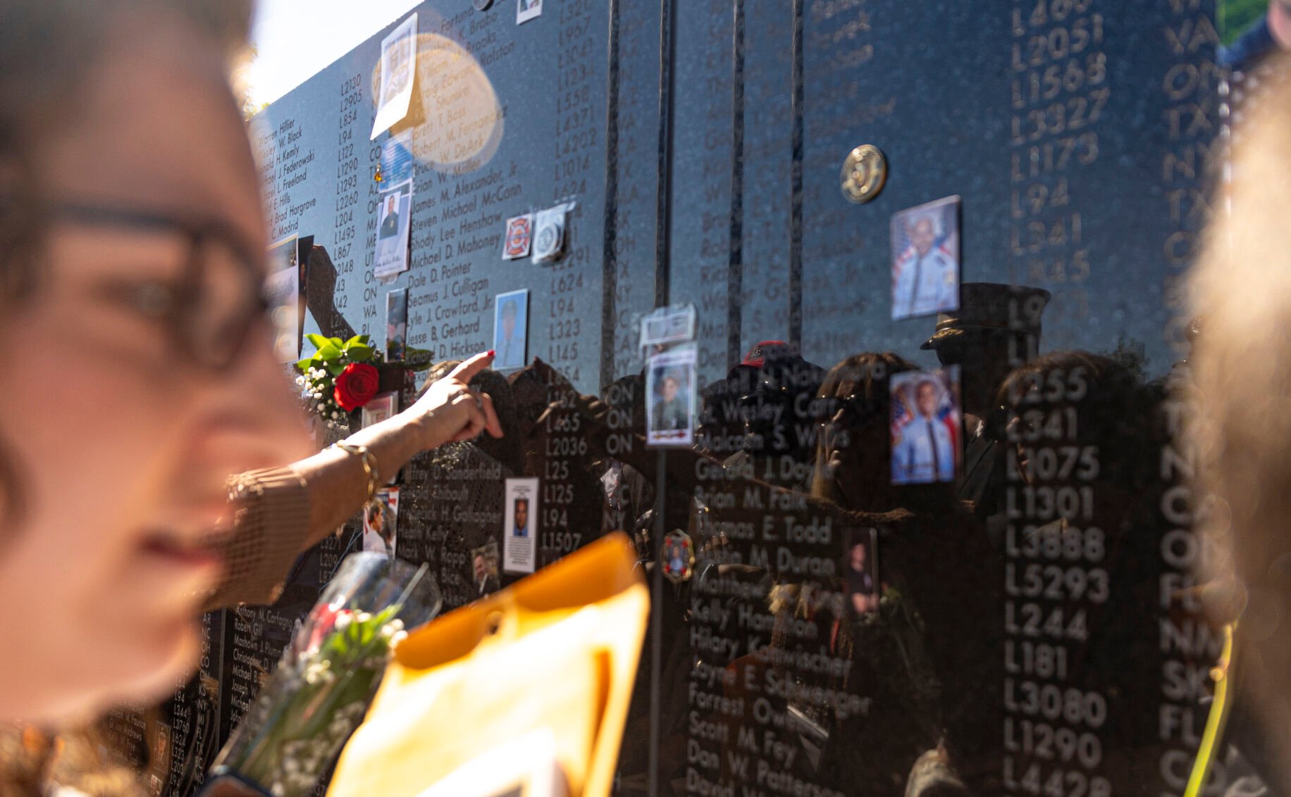 Judy Simonetti of New York looks at the newest addition to the memorial alongside the crowds of others trying to get etchings of their loved one’s names before the Fallen Fire Fighter Memorial 2023 Observance in Memorial Park on Saturday, September 16, 2023. (Gabi Broekema)