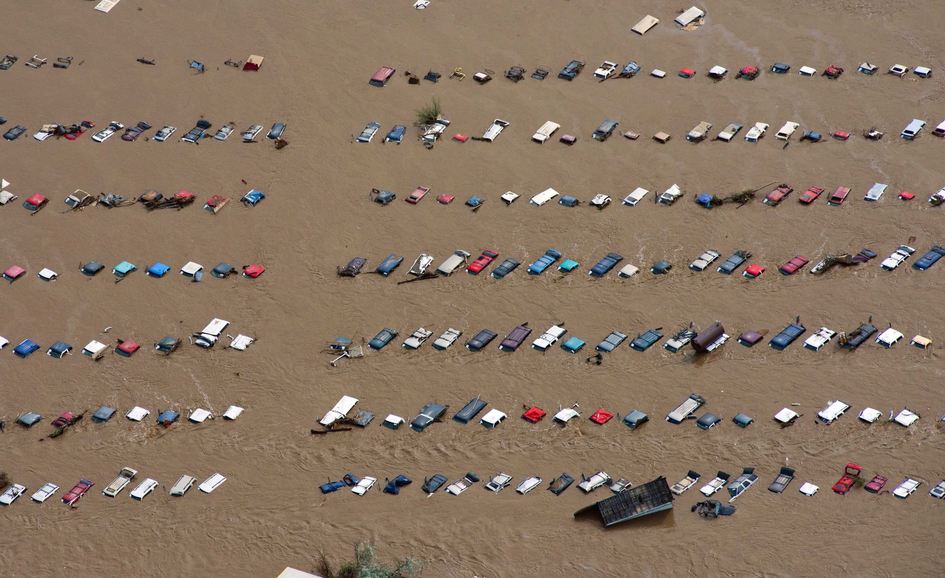 FILE PHOTO: A field of parked cars and trucks sits partially submerged near Greeley, Colo., Saturday, Sept. 14, 2013, as debris-filled rivers flooded into towns and farms miles from the Rockies. Hundreds of roads, farms and businesses in the area were damaged or destroyed by the floodwaters. (AP Photo/John Wark, File) (John Wark/Associated Press)