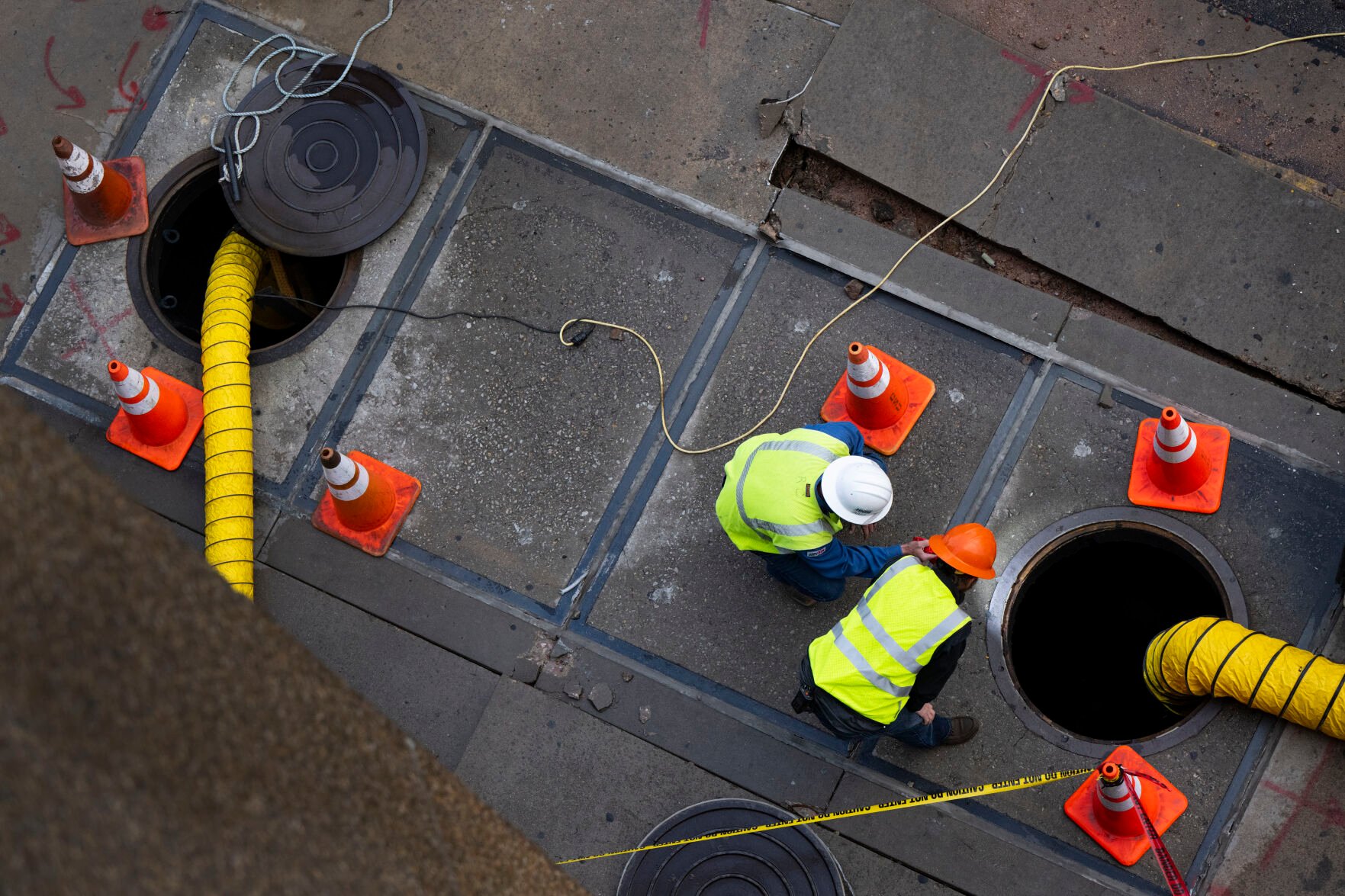 Colorado Springs Utilities workers looks through a manhole on Kiowa Street next to the bus station Monday morning, Sept. 11, 2023, as they investigate the damage after an early morning fire underground caused power outages and evacuations in the downtown area. (The Gazette, Christian Murdock) (Christian Murdock/The Gazette)