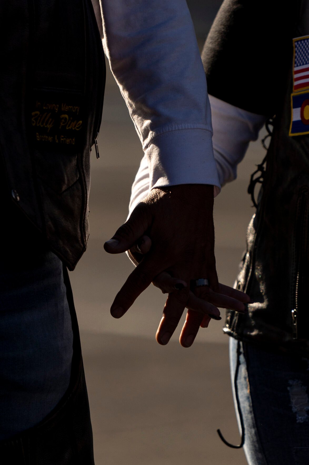 Two motorcycle riders hold hands while preparing for the Ride of Honor on Saturday, September 16, 2023. (Gabi Broekema)