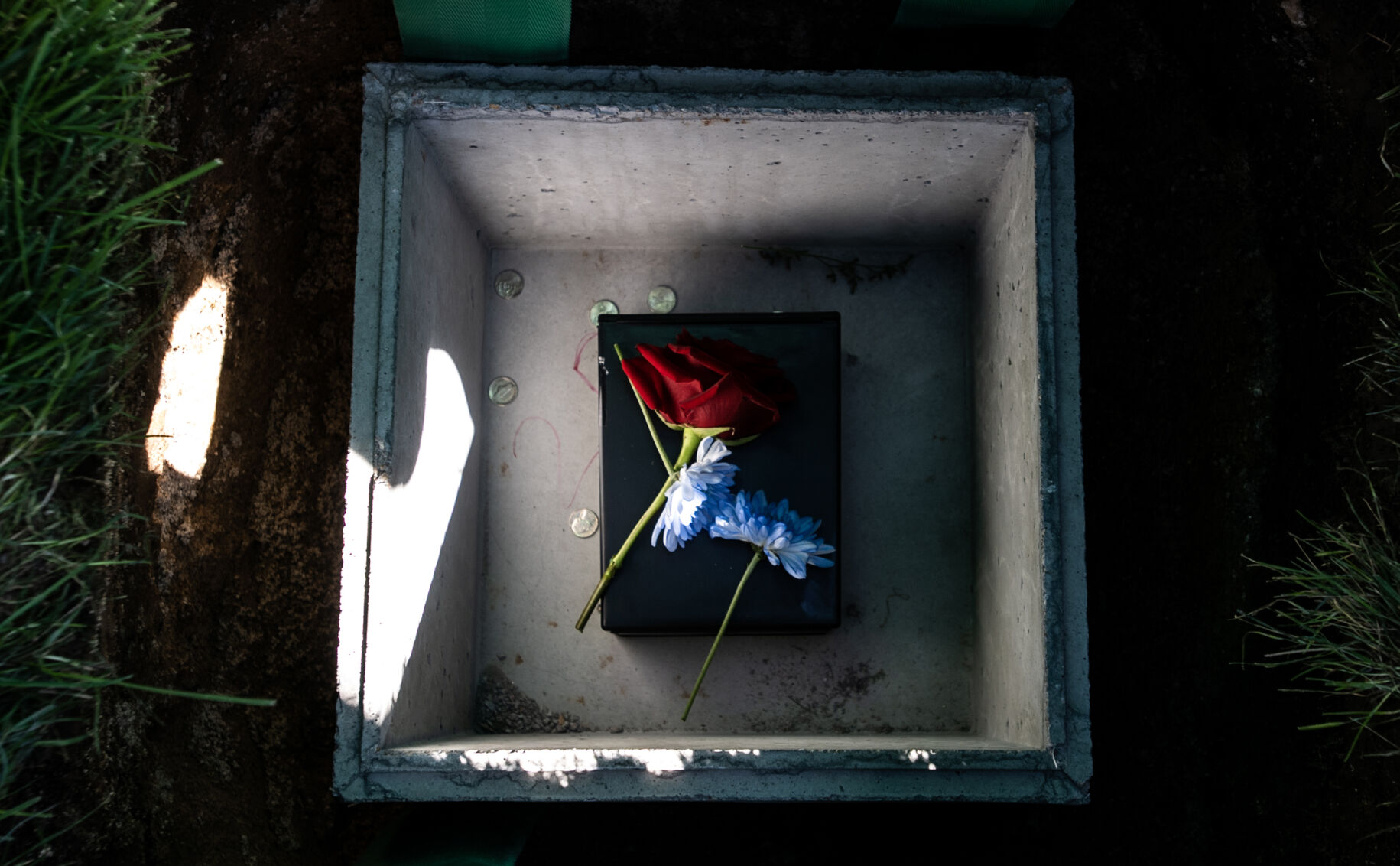 Flowers and nickels added by family and friends of Col. Karol Bobko’s lie in his urn vault following a funeral service at the United States Air Force Academy Cemetery on Friday, Sept. 8, 2023. Some of Bobko’s friends and family participated in the military tradition of leaving a coin on a grave as a show of respect to fallen pilots. (Parker Seibold, The Gazette) (Parker Seibold)
