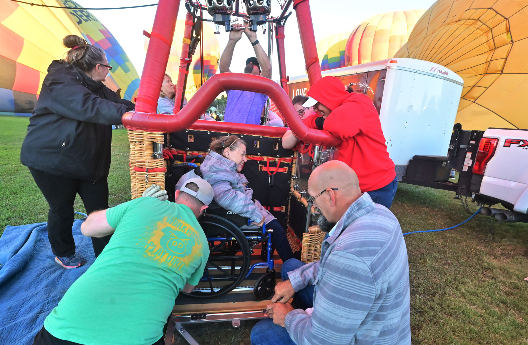 Ginger Gustafson is secured into a balloon in her wheelchair before taking a ride during the Colorado Springs Labor Day Lift Off. Gustafson became the first wheelchair-bound person to take flight in Colorado Springs in the specialized balloon designed for people with disabilities on Monday, Sept. 4, 2023. Pilot Mike “Heff” Heffron, pilot of the Coddiwomple, has the only balloon like it in the United States. (Photo by Jerilee Bennett, The Gazette)