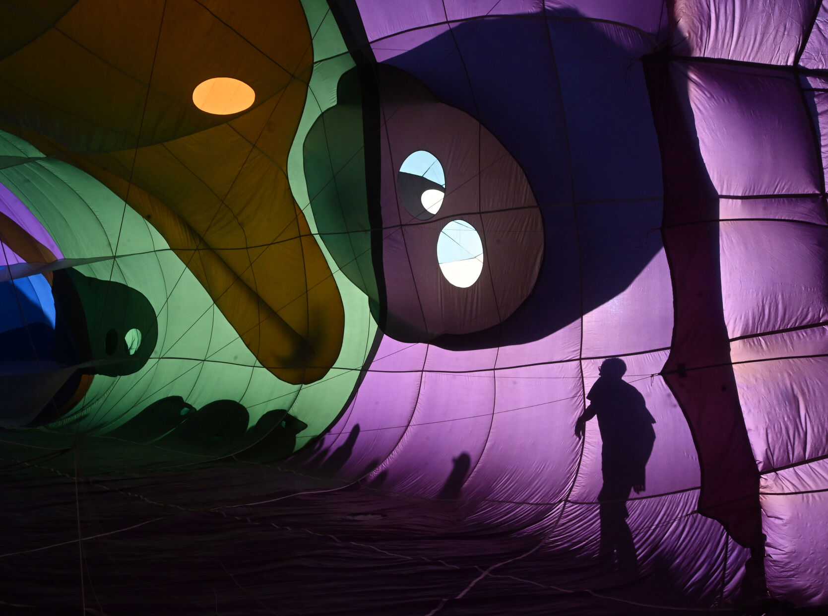 Pilot Dave Reineke (right) walks around the walls of Peg Leg Pete the Pirate Parrot balloon, checking the sides of the balloon during the cold inflate on Sunday, Sept. 3, 2023. The balloons didn’t lift off on Sunday morning, because of winds at higher altitudes, but most still participated with a stationary inflation to please the thousands. (Jerilee Bennett, The Gazette)