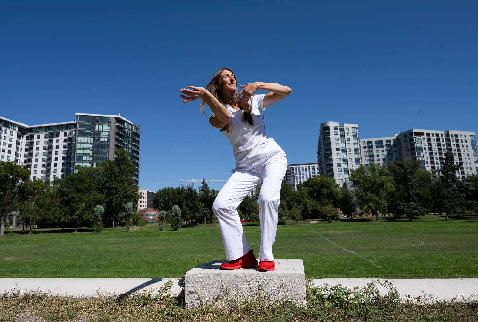 Denver nurse and dancer Tara Rynders conducts group workshops that offer the arts as an entry point into healing from burnout, traumatic stress and what she calls 'moral injury.' She was photographed at Sunken Gardens Park in Denver on break from her shift at Denver Health on Sept. 6, 2023. (Christian Murdock, The Denver Gazette)