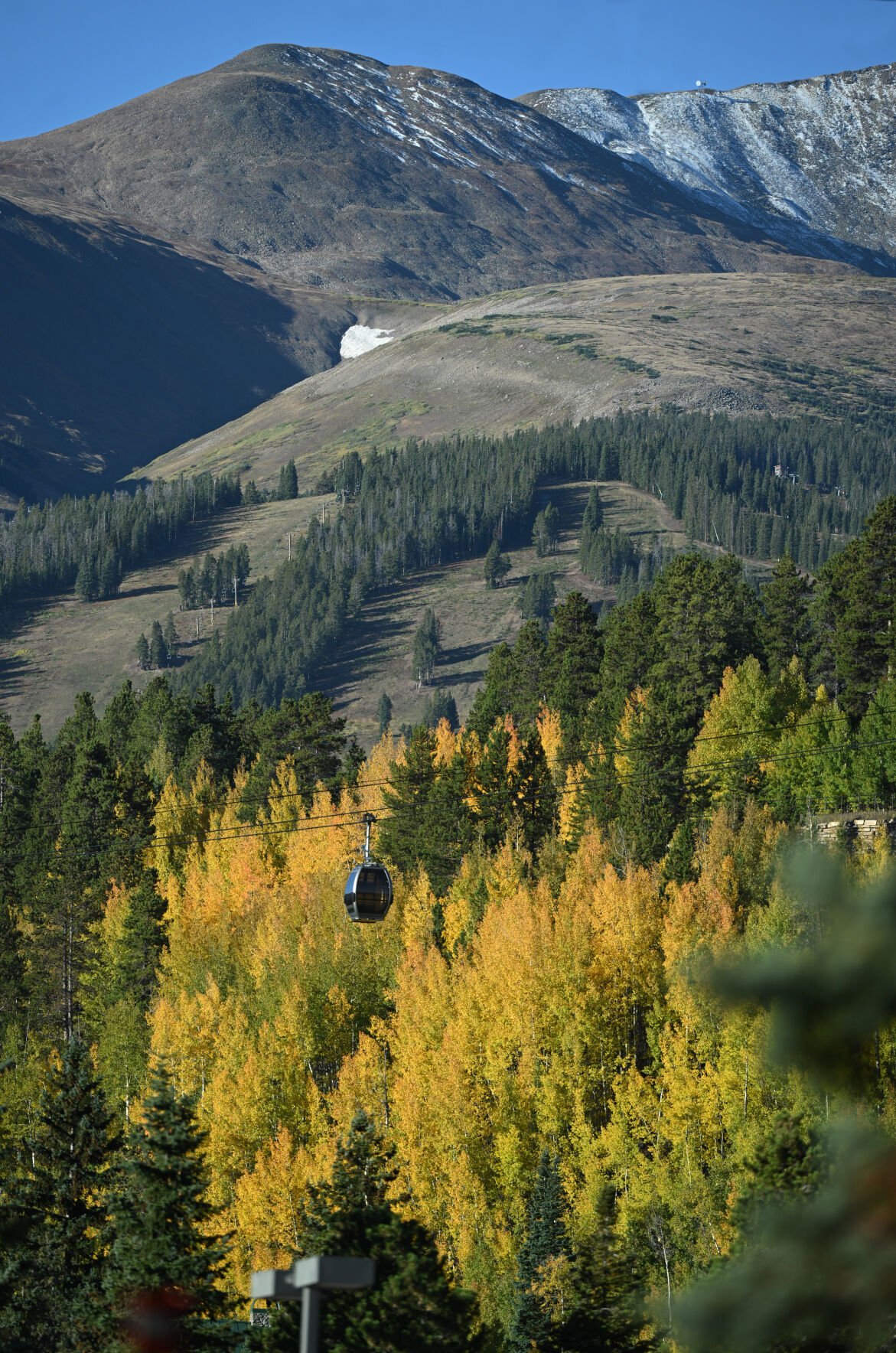 The snow has started on the mountains above the Breckenridge ski area while aspens change colors near the gondola on Monday, Sept. 25, 2023. (Photo by Jerilee Bennett, The Gazette)