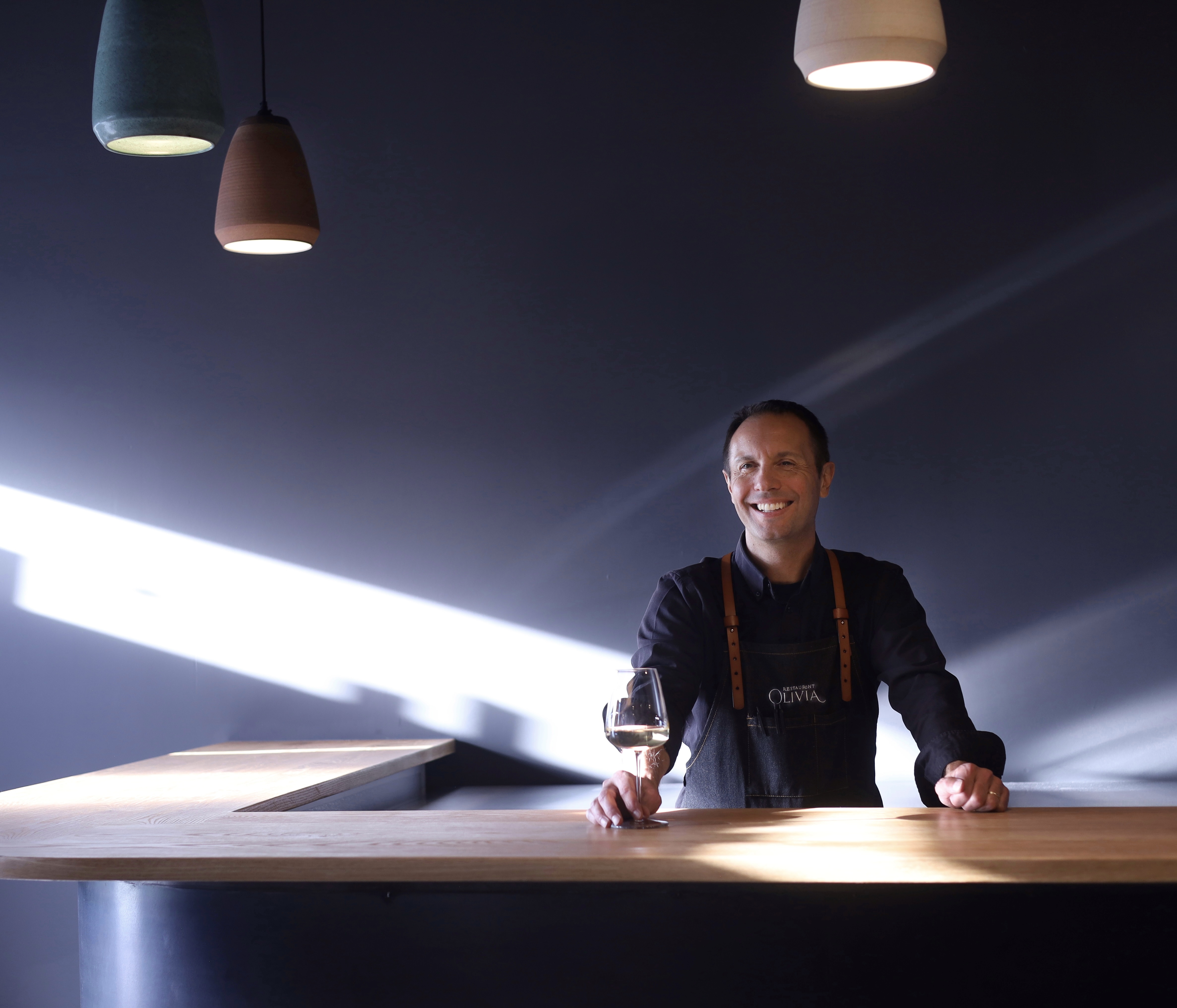 Wine director Scott Thomas stands behind a newly-installed bar at Restaurant Olivia. The recent renovation more than doubled the square footage of the restaurant and its new design was spearheaded by Julie Brayton of Brayton Interiors. (Courtesy Restaurant Olivia)