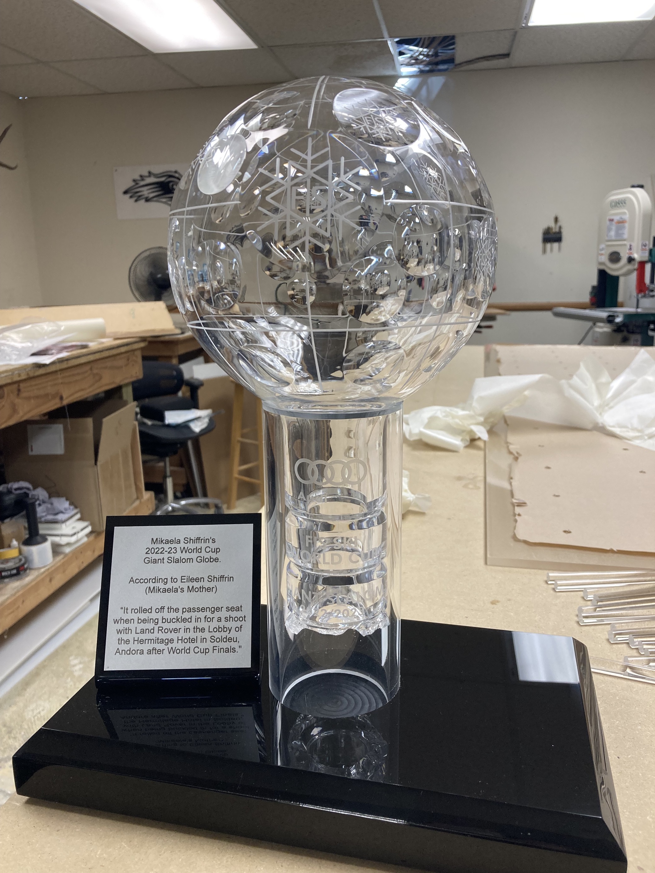 Mikaela Shiffrin's World Cup Giant Slalom globe sits in a stand with a plaque describing how the trophy broke. 
