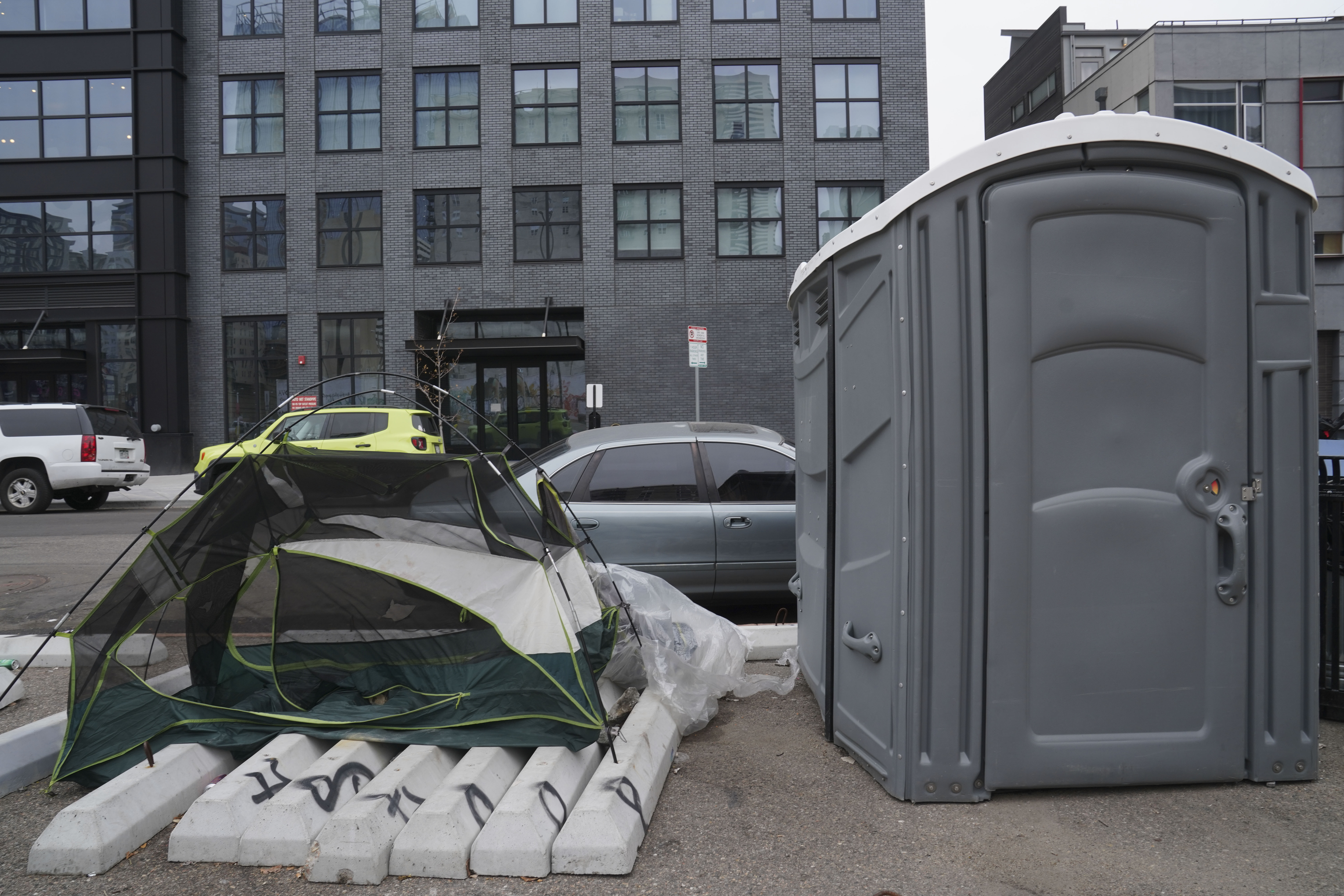 A tent sits on parking blocks next to a porta potty near 21st and Curtis Street on Thursday, Oct. 26, 2023 in Denver, Colorado. Some 50 homeless people at the encampment are being offered hotel housing as cold weather approaches, according to the mayor’s office. The city plans to sweep the encampment. (PHOTO: Rebecca Slezak/Special to The Denver Gazette) (Rebecca Slezak)