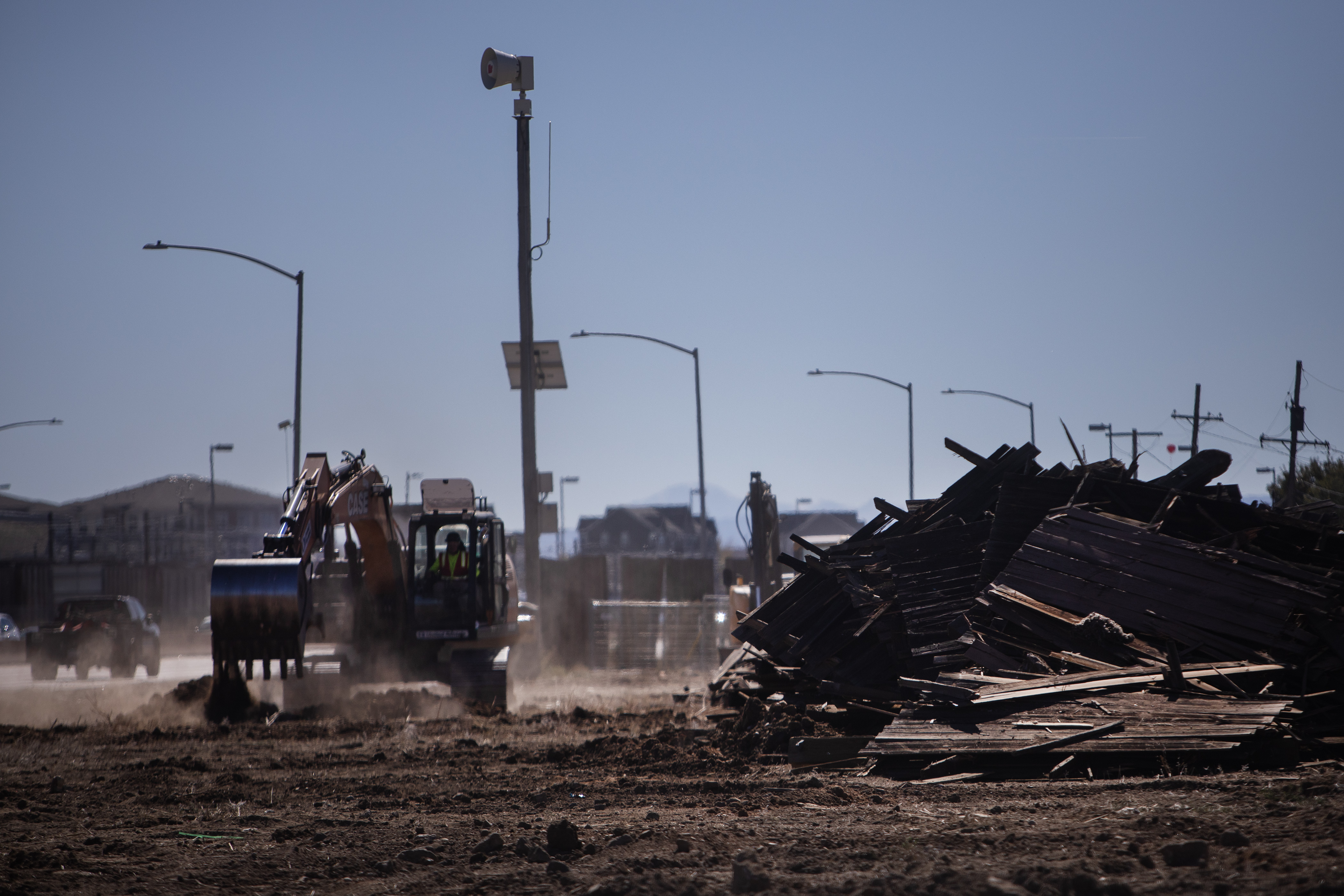 Sections of the large wooden fence that ran along the sidewalk of South Santa Fe Drive are piled up as an excavator digs at the site of the first planned micro-community at 2301 South Santa Fe Drive on Monday, Oct. 16, 2023, in Denver. (Timothy Hurst/Denver Gazette) (TimHursttim.hurst@gazette.comhttps://secure.gravatar.com/avatar/aca82bd62b4ee425c598527cd6faa1b1?d=mm&r=g)