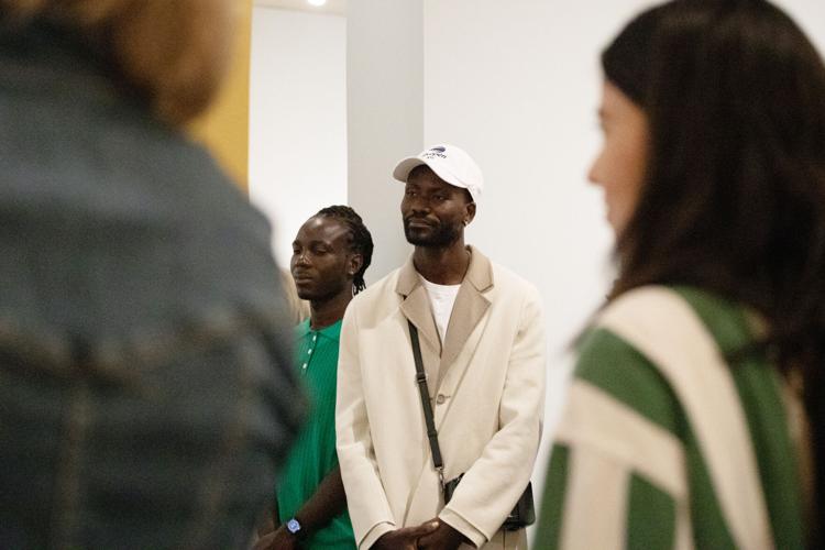 Amoako Boafo listens to Larry Ossei-Mensah speak during his exhibition's opening on Oct. 6, 2023.