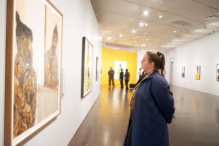 Courtney Woodruff, a museum employee, walks through Amoako Boafo's exhibit