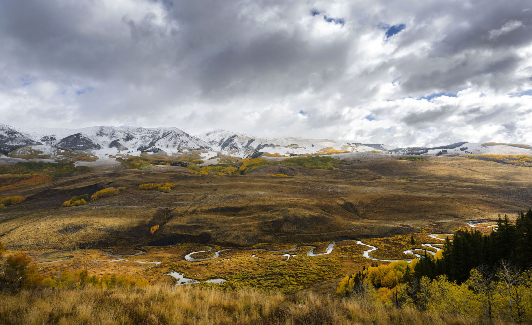 An overnight snowstorm dusts the Elk Mountains as the East River flows through the fall foliage near Gothic, Colo., Tuesday, Oct. 3, 2023. (The Gazette, Christian Murdock) (Christian Murdock/The Gazette)