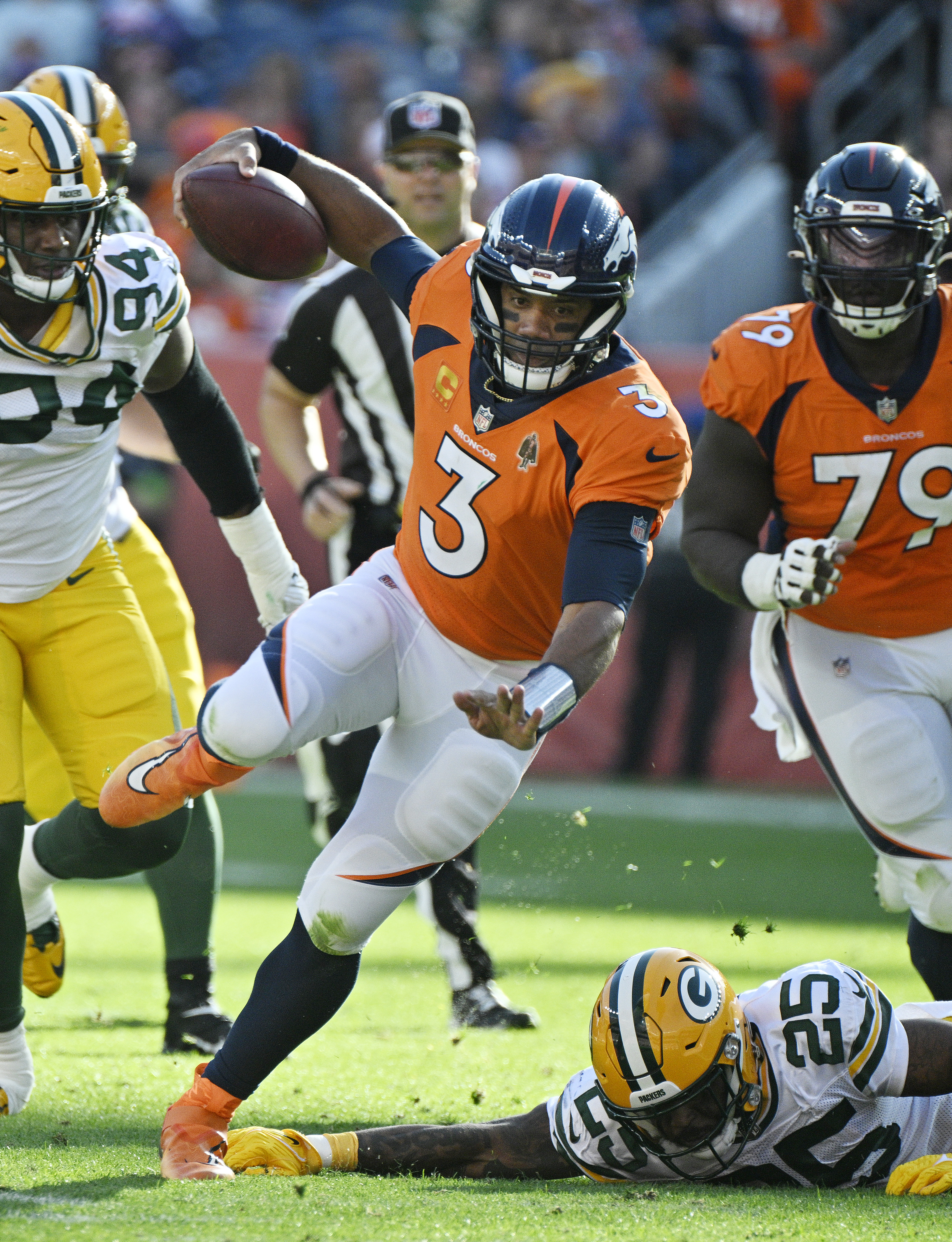 Broncos quarterback Russell Wilson sidesteps the tackle of Packers Keisean Nixon for a first down run at the end of the 2nd quarter during a game at Empower Field at Mile High on Sunday, Oct. 22, 2023. The Broncos won the game 19-17. (Photo by Jerilee Bennett, The Gazette)