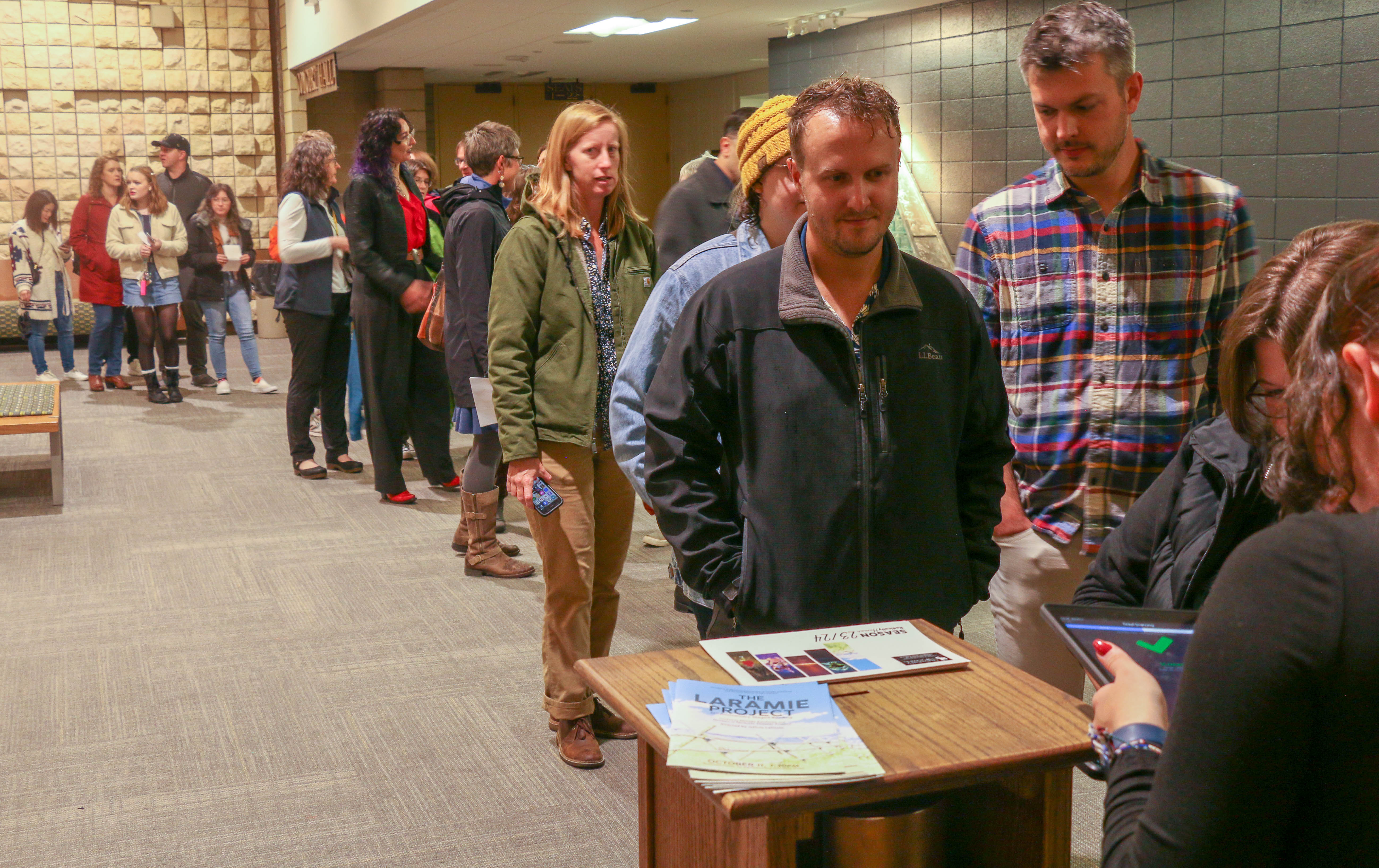 A considerable line forms of people entering