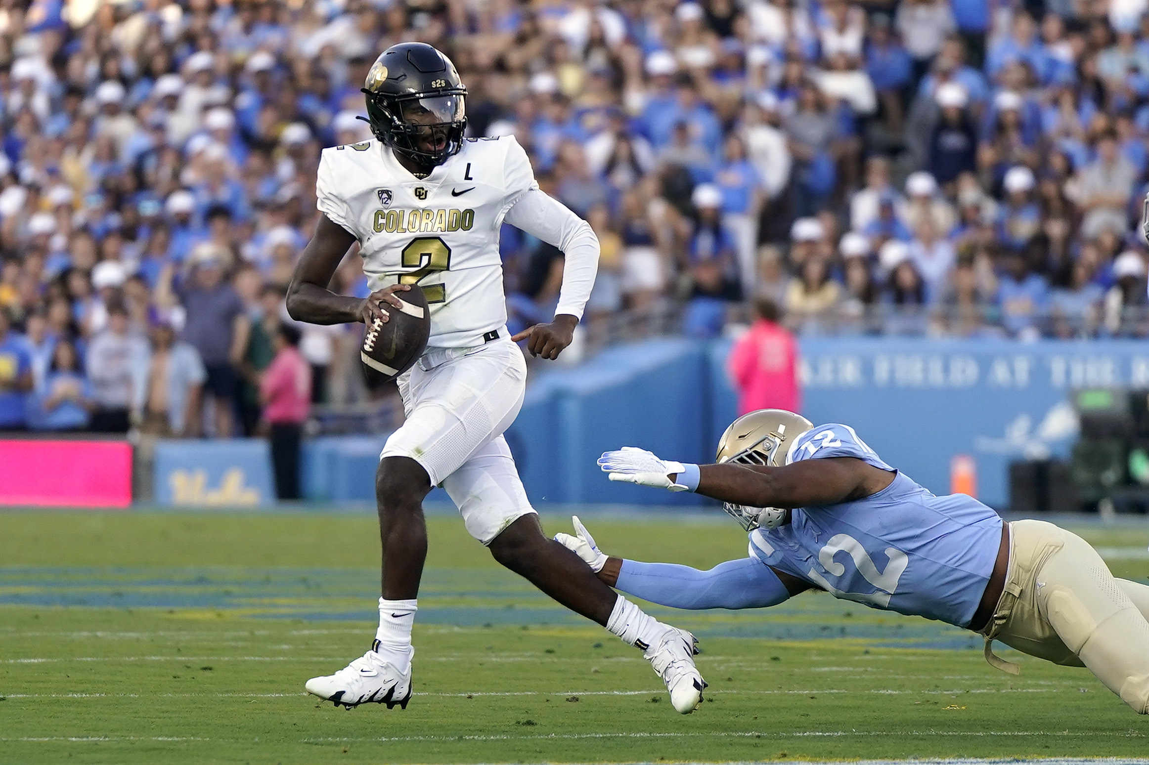 Colorado quarterback Shedeur Sanders, left, escapes a tackle by UCLA defensive lineman Grayson Murphy during the first half of an NCAA college football game Saturday, Oct. 28, 2023, in Pasadena, Calif. (AP Photo/Mark J. Terrill) (Mark J. Terrill)