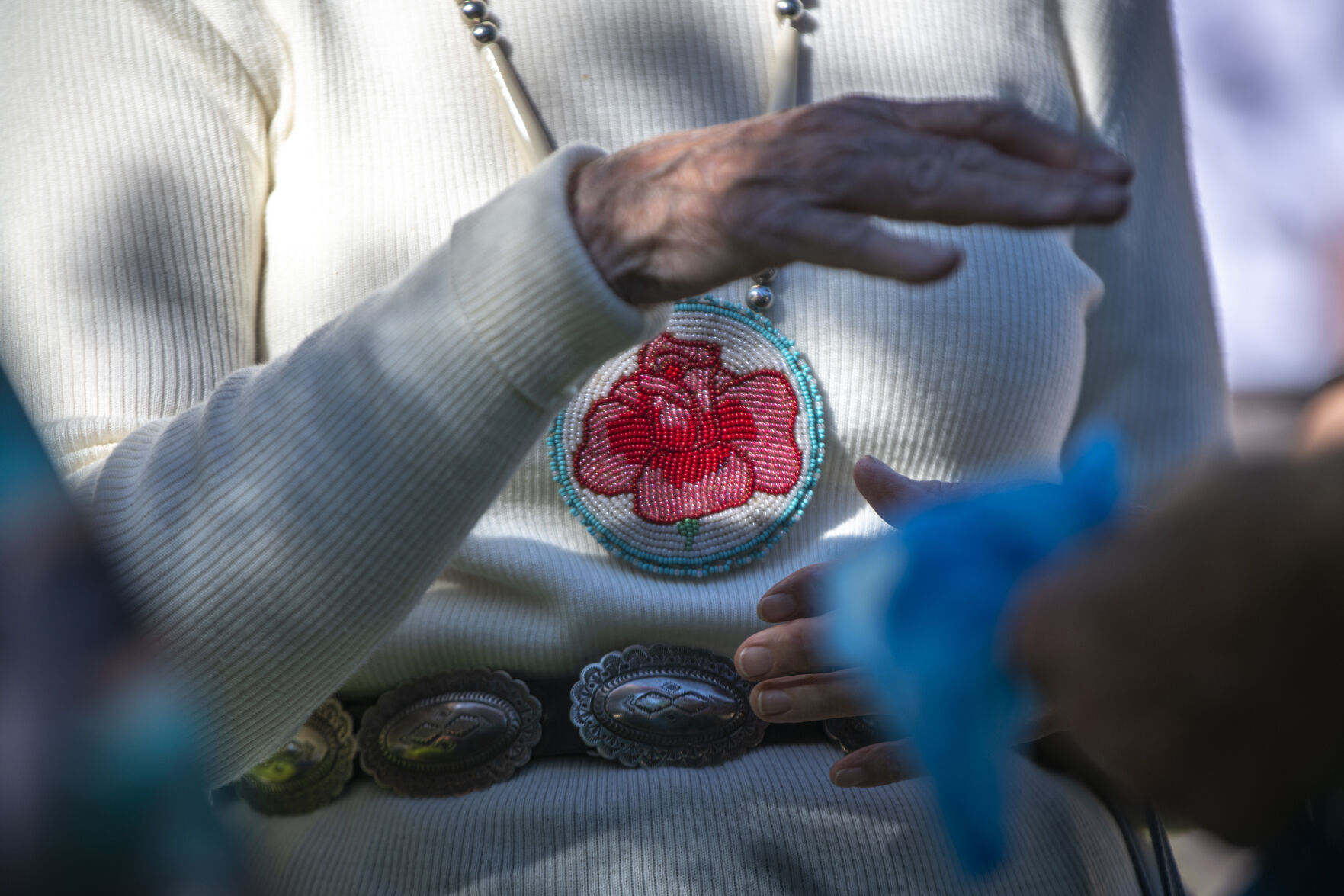 An attendee wears an intricately beaded flower necklace to the ‘Planting of the Peace Tree Ceremony,’ at Mansions Park in Manitou Springs, Colo. on Sunday, October 8, 2023. (Gabi Broekema, The Gazette) (Gabi Broekema)