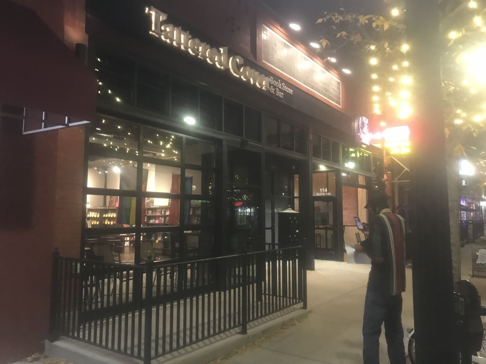 Azariah Williams, right, takes a picture of the Tattered Cover bookstore in downtown Colorado Springs as it closes its doors for the final time. (O'Dell Isaac/The Gazette)