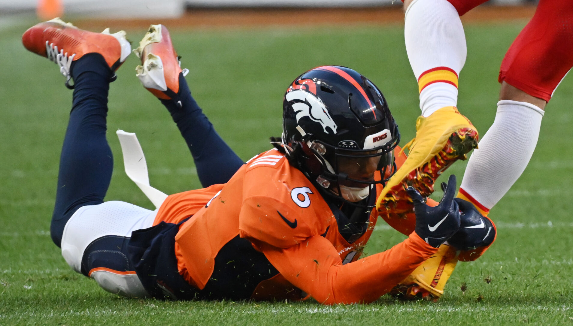 Denver Broncos safety P.J. Locke (6) gets a hold of Kansas City Chiefs tight end Travis Kelce (87) by the ankles and brings him down during a game at Empower Field at Mile High on Sunday, Oct. 30, 2023. The Broncos defeated the Chiefs 24-9. (Photo by Jerilee Bennett, The Gazette)