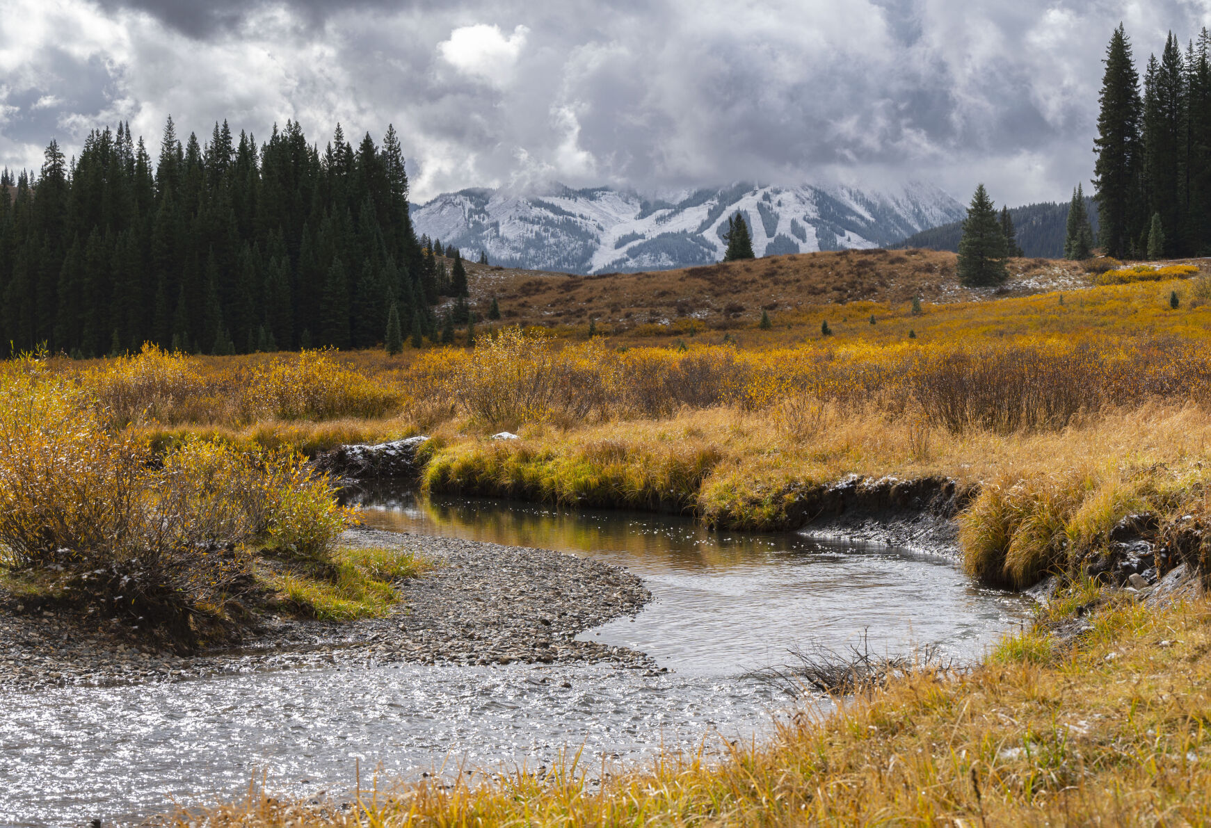 The East River flows though the fall foliage as a recent snowfall dust Mt. Crested Butte in the background Tuesday, Oct. 2, 2023. (The Gazette, Christian Murdock) (Christian Murdock/The Gazette)