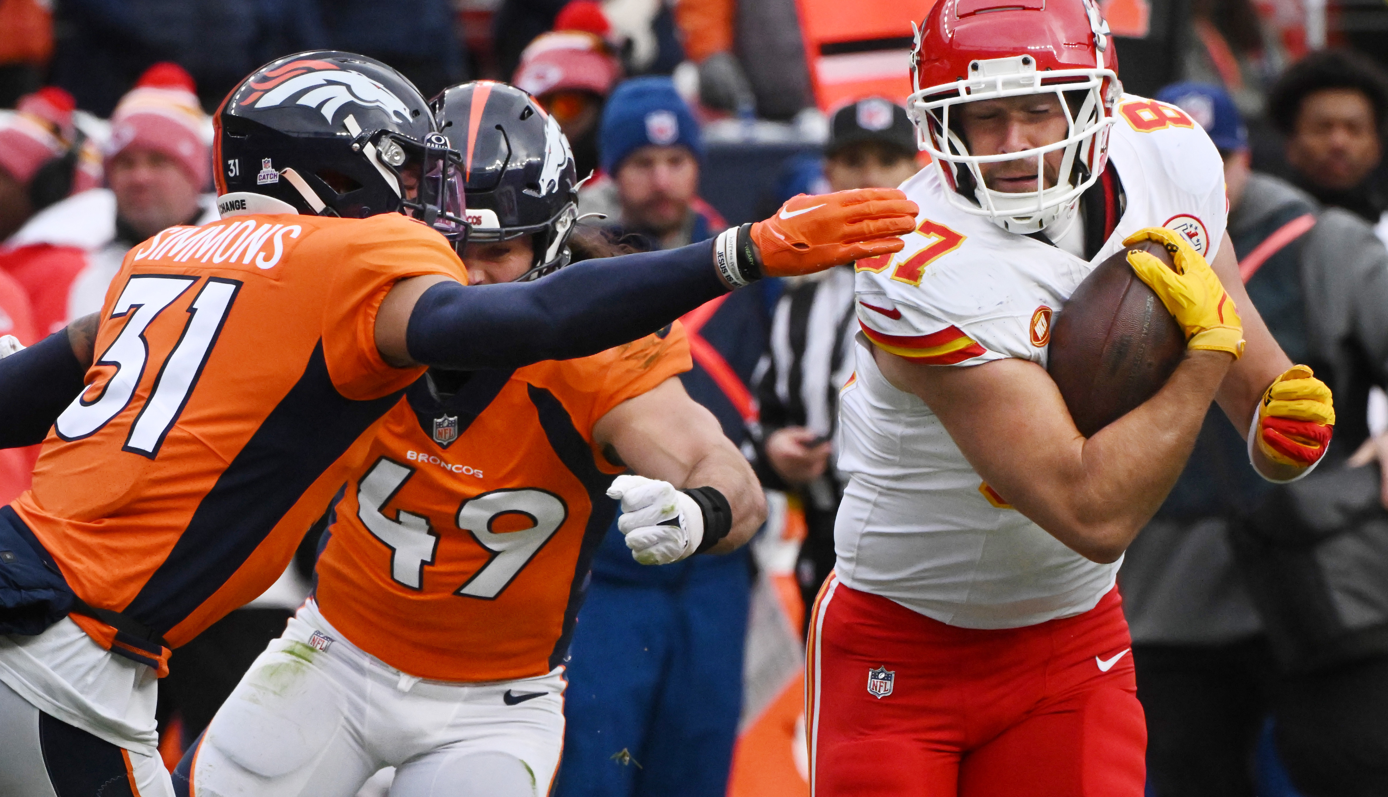 Denver Broncos safety Justin Simmons (31) and Denver Broncos linebacker Alex Singleton (49) go after Kansas City Chiefs tight end Travis Kelce (87) in the third quarter at Empower Field at Mile High on Sunday, Oct. 29, 2023. The Broncos beat the Chiefs 24-9. (Photo by Jerilee Bennett, The Gazette)
