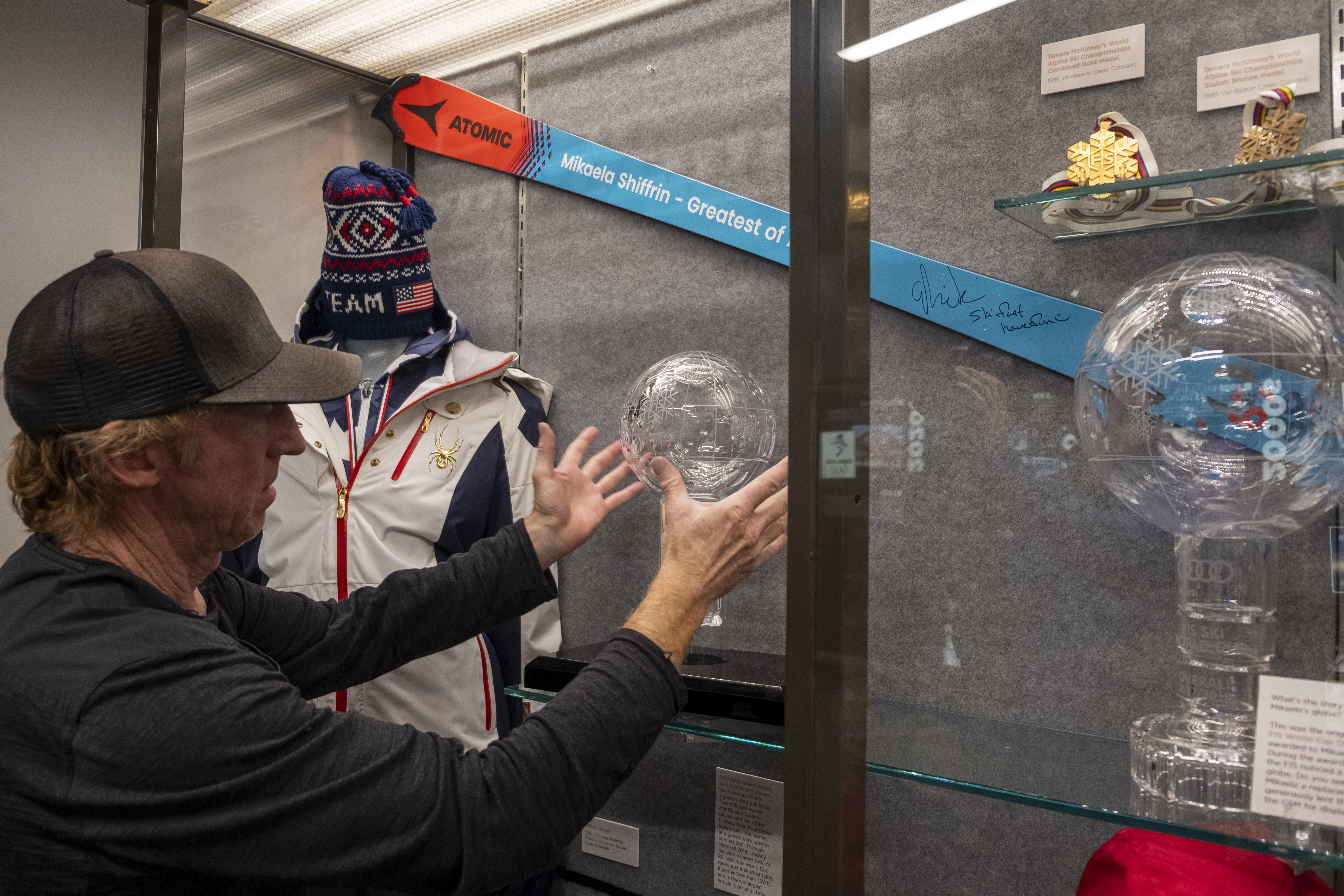 Pro skier Chris Anthony places in a display case a new edition to the exhibit, a 2022-23 World Cup globe trophy donated by Mikaela Shiffrin after the ski racer broke it while filming a car commercial in Andorra in March 2023. (JonathanIngrahamDigital Strategistjonathan.ingraham@denvergazette.comhttps://denvergazette.com/content/tncms/avatars/c/dd/7f0/cdd7f086-b693-11ec-b373-bba598953eb6.fc0f5608a6f1144f64f080f771bd904d.png)