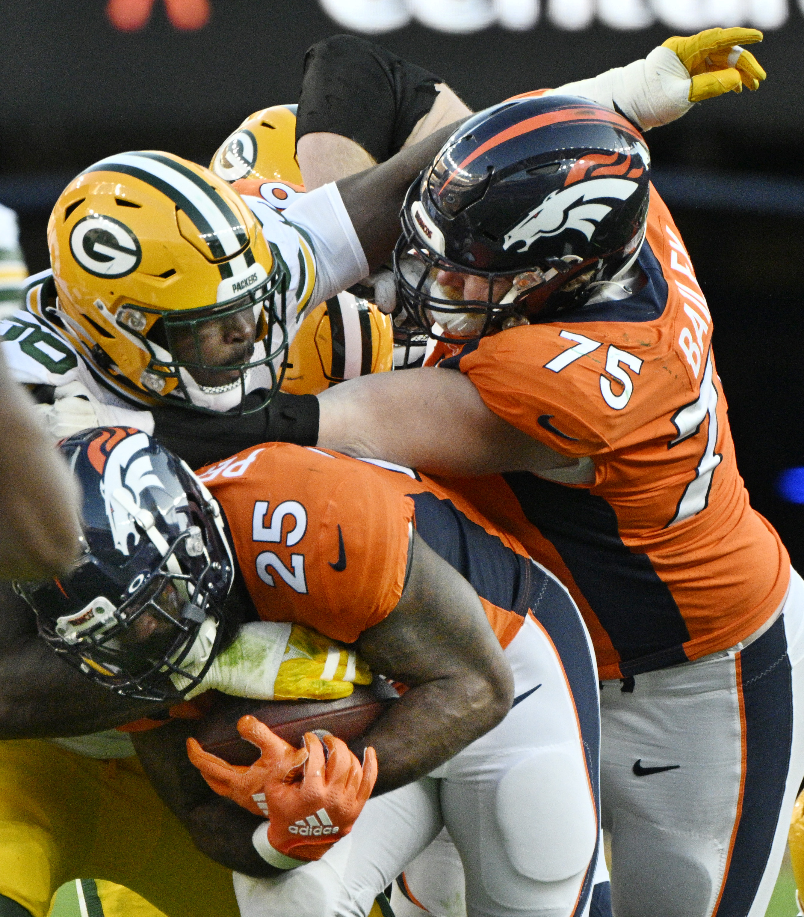Denver Broncos offensive tackle Quinn Bailey (75) protects Denver Broncos running back Samaje Perine (25) from a Packers defensive player during a game at Empower Field at Mile High on Sunday, Oct. 22, 2023. (Photo by Jerilee Bennett, The Gazette)