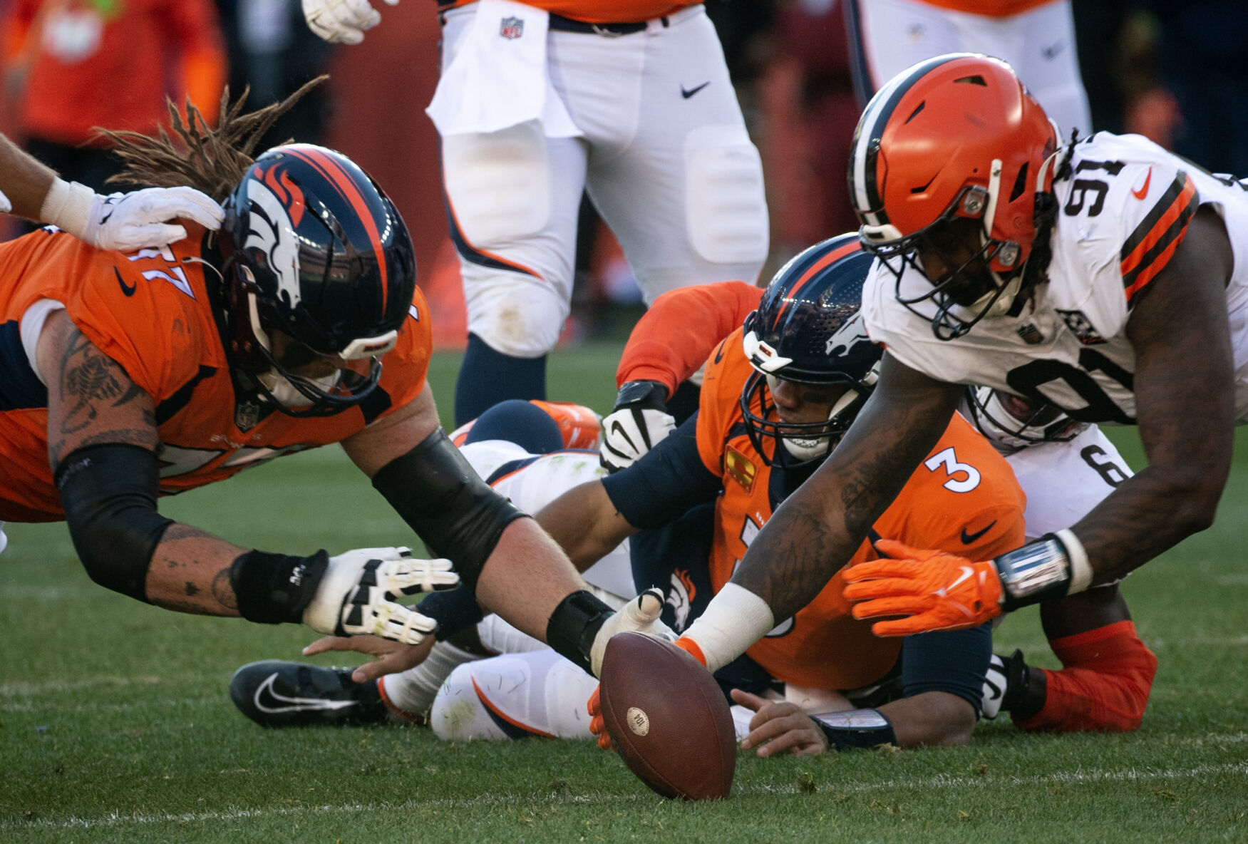 Denver Broncos guard Quinn Meinerz (77) and Cleveland Browns defensive end Alex Wright (91) reach for a fumbled ball in the first half of a game on Sunday, Nov. 26, 2023, at Empower Field at Mile High in Denver, Colo. (Parker Seibold, The Gazette) (Parker Seibold)