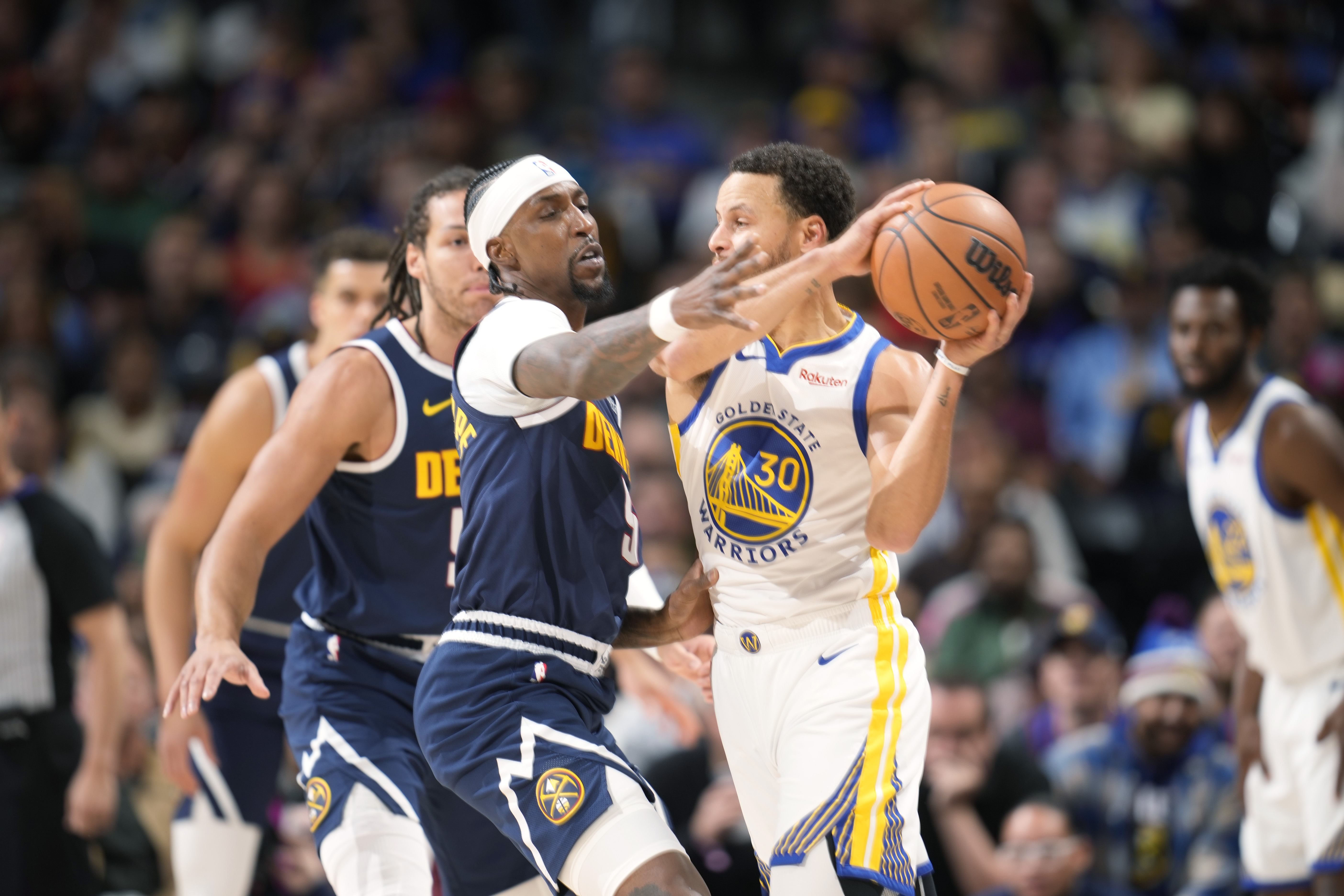 Denver Nuggets guard Kentavious Caldwell-Pope (5) guards Golden State Warriors guard Stephen Curry (30) in the first half of an NBA basketball game Wednesday, Nov. 8, 2023, in Denver. (AP Photo/David Zalubowski) (David Zalubowski)