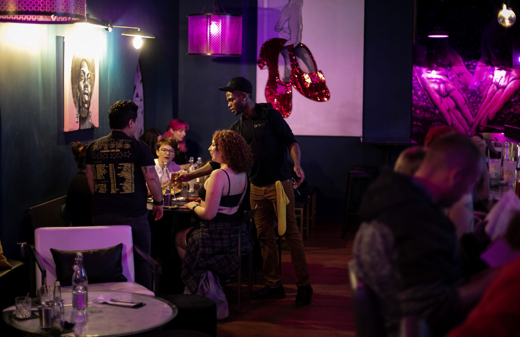 Icons employee Leo Nova, right, and general manager T. Paul, left, talk with patrons gathered to mingle and play games last week during Femmes and Thems night. (Parker Seibold, the gazette)