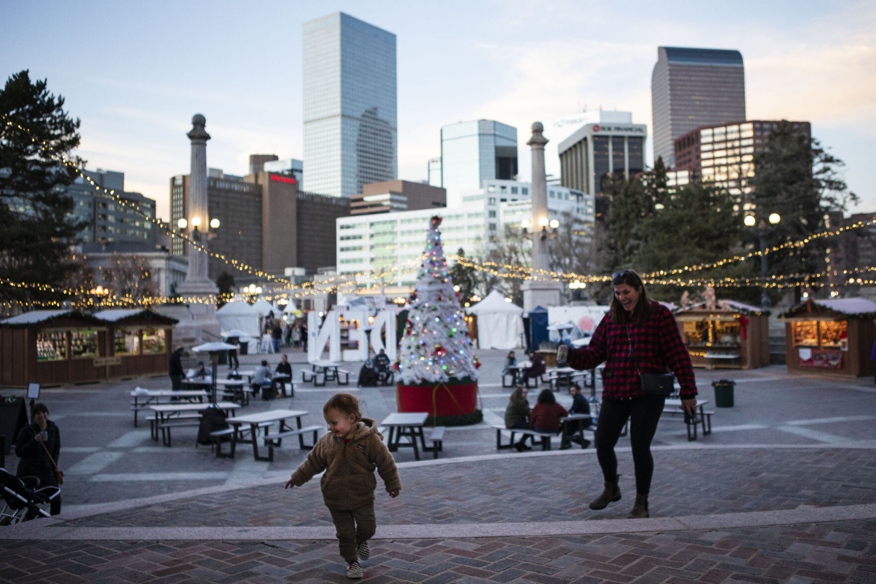 Milo Andres, 2, dances for Emily Lawson on the steps of the amphitheater at the Denver Christkindl Market on Mondayat Civic Center Park.The market closes for the season Thursday. (Denver Christkindl Market at Civic Center Park. Timothy Hurst)