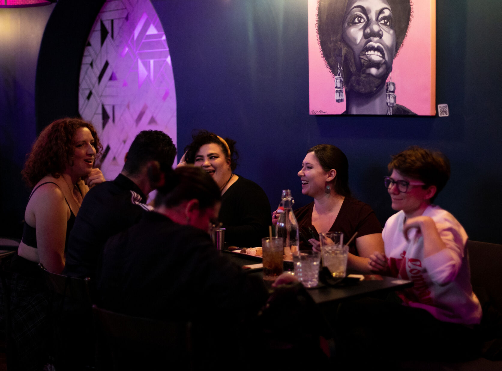 A group of people mingle and play a card game last week during a Femmes and Thems night at Icons. (Parker Seibold, the gazette)