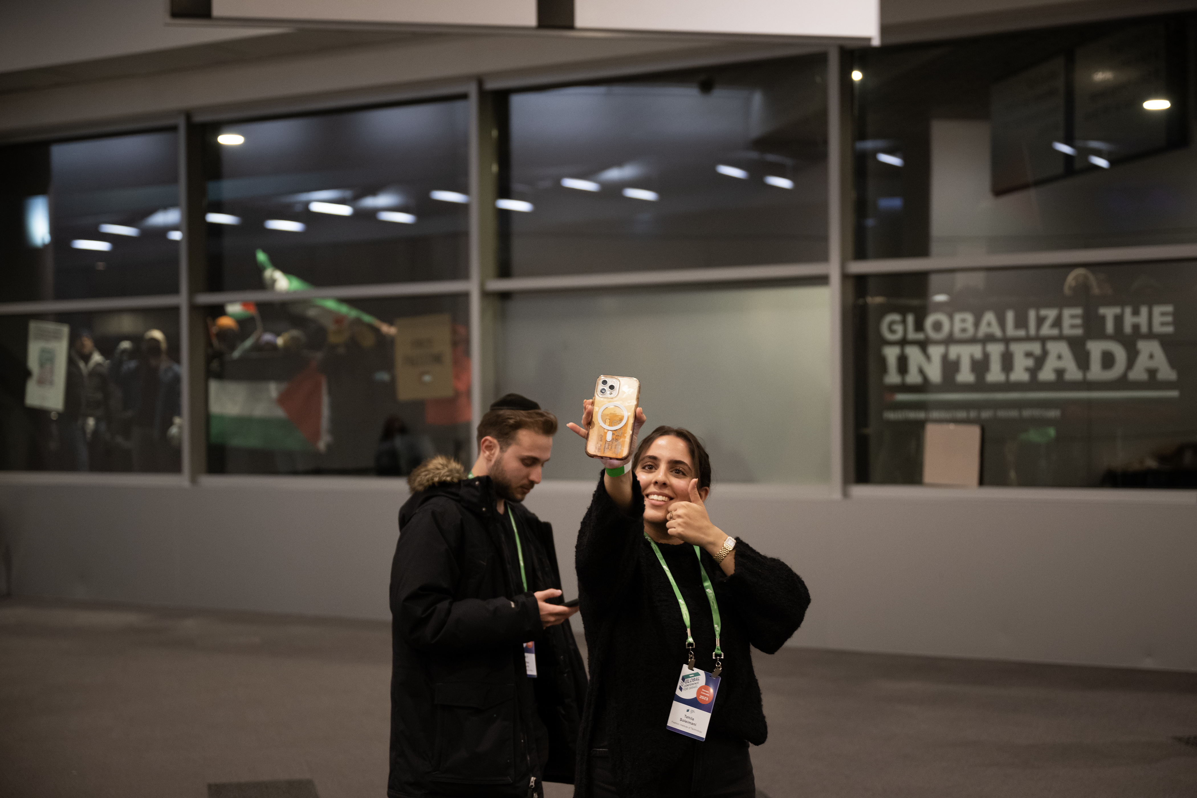 A conference attendee takes a selfie in front of protestors banging on the windows during a protest to disrupt the Jewish National Fund-USA’s Global Conference for Israel’s Opening Plenary on Thursday, November 30, 2023, at the Colorado Convention Center in Denver, Colo. (Timothy Hurst/Denver Gazette) (TimHursttim.hurst@gazette.comhttps://secure.gravatar.com/avatar/aca82bd62b4ee425c598527cd6faa1b1?d=mm&r=g)
