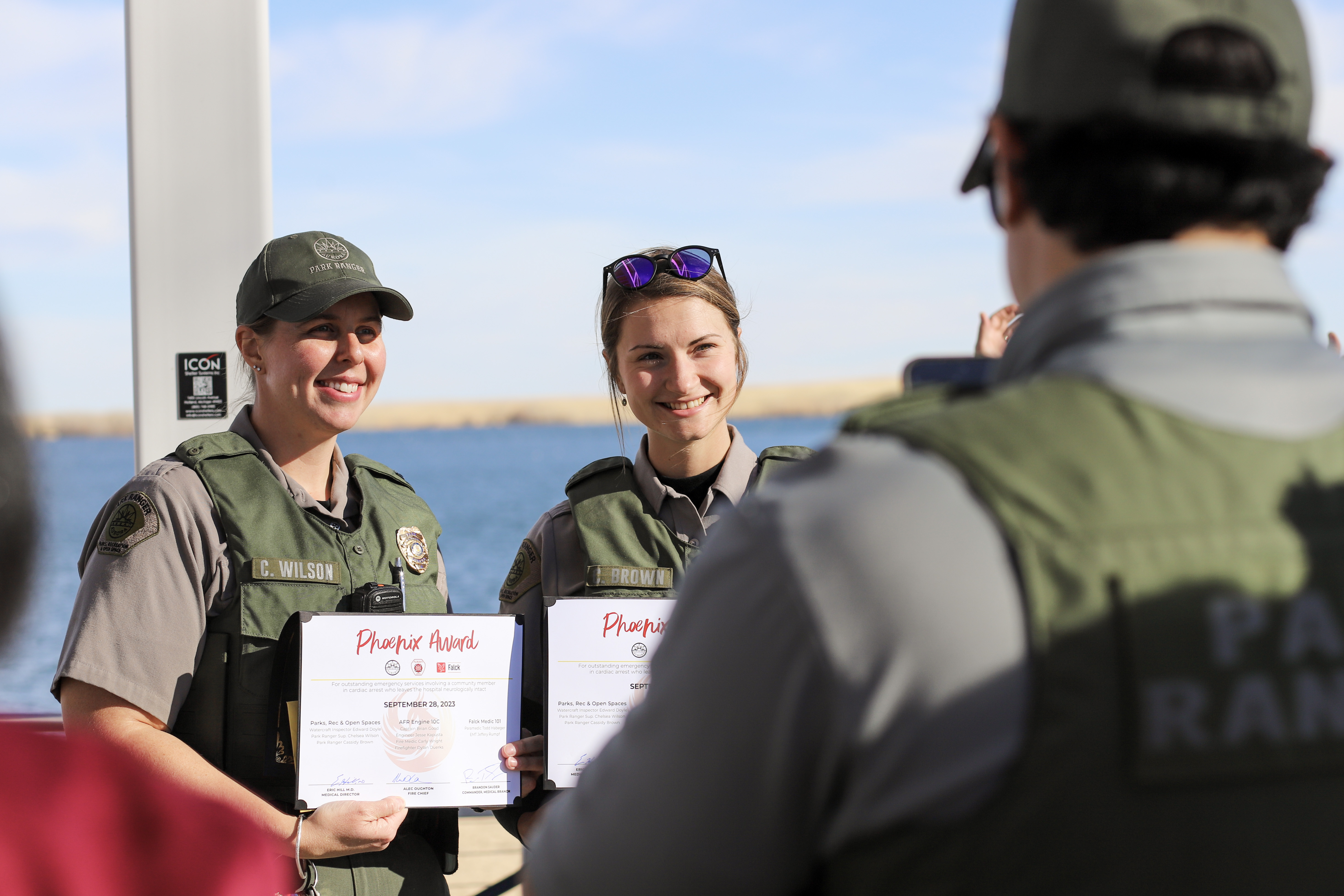 Aurora park rangers Chelsea Wilson and Cassidy Brown pose for photos with their Phoenix Awards. Wilson and Brown responded with CPR and an AED when Dwayne Williams unexpectedly went into cardiac arrest at Aurora Reservoir in late September, contributing to saving his life. (Kyla Pearce)