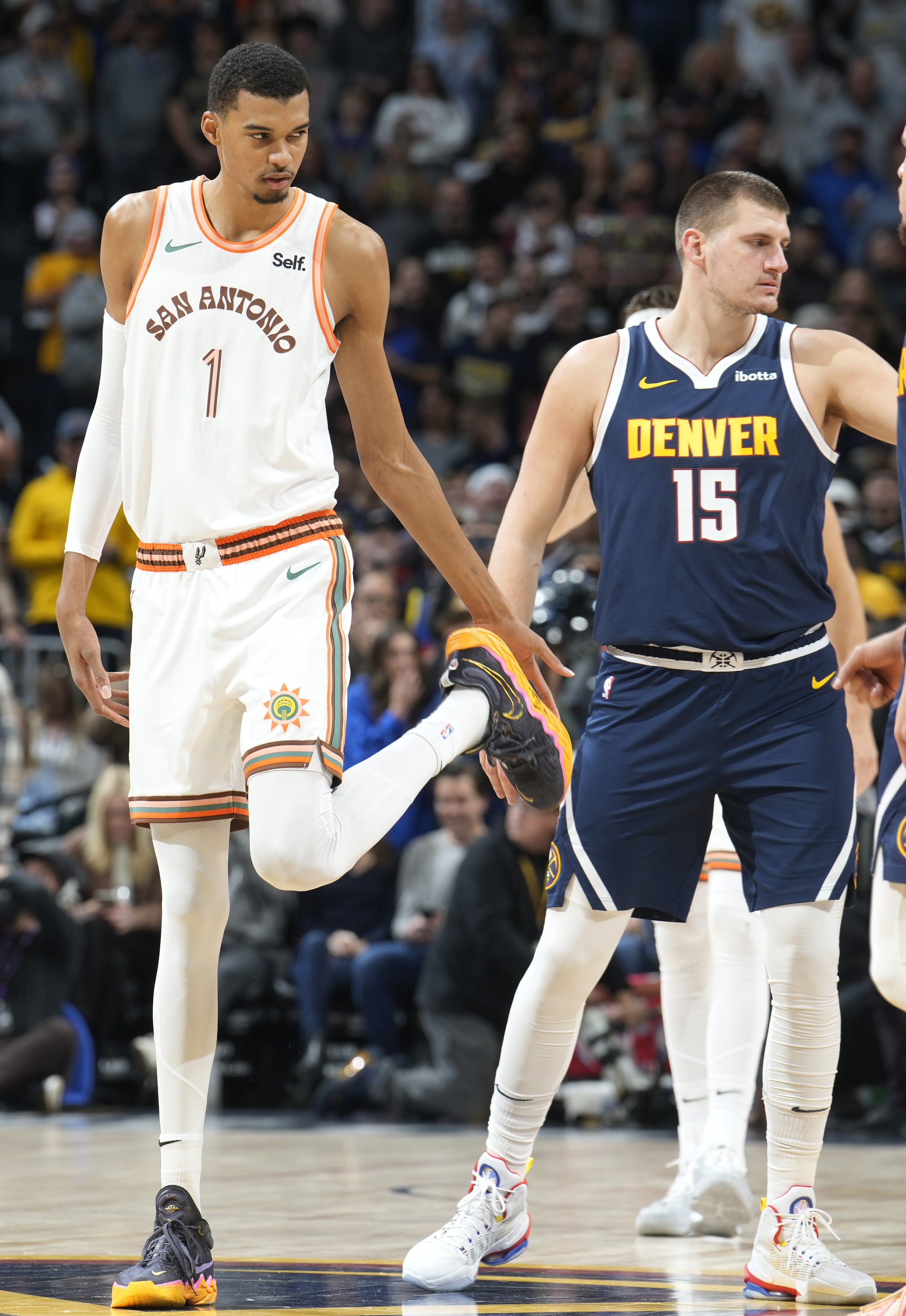 San Antonio Spurs center Victor Wembanyama, left, waits to jump the ball with Denver Nuggets center Nikola Jokic (15) in the first half of an NBA basketball game Sunday, Nov. 26, 2023, in Denver. (AP Photo/David Zalubowski) (David Zalubowski)