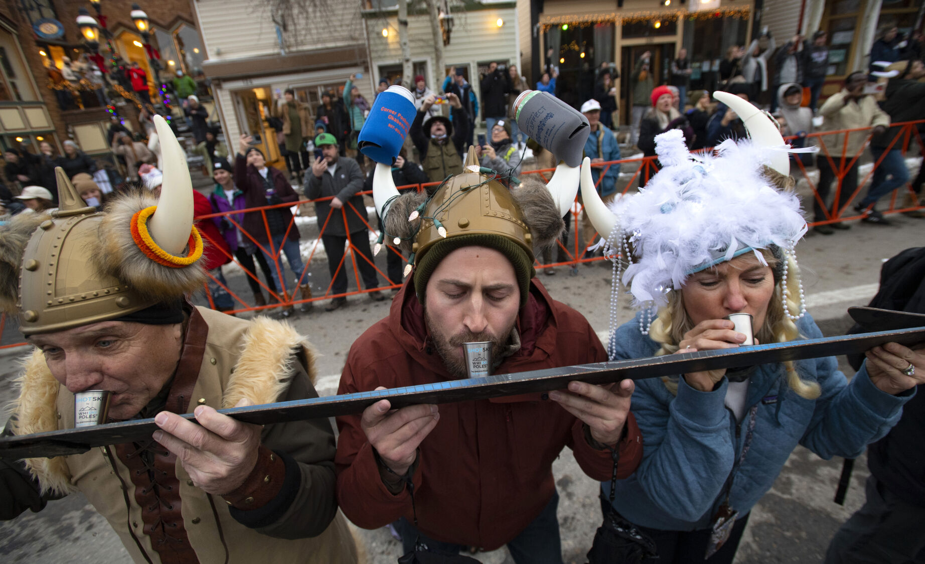 Cliff Black, left, his son Justin Black and wife Sheila Black of Colorado Springs, take a shot of whiskey while the town of Breckenridge attempts to break the shot ski record with 1,333 participants before the start of the Ullr Festival parade Thursday, Dec. 9, 2021 in downtown Breckenridge, Colo. The 58th annual Ullr Festival, named after the Norse god of snow, began Thursday night and runs through Dec. 12. (The Gazette, Christian Murdock) (Christian Murdock/The Gazette)
