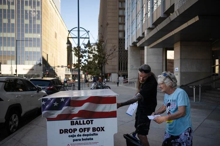 Mother and son Mary and Chuck Lovell drop off their ballots Tuesday outside the Webb Municipal Building in Denver. (Gazette photo)