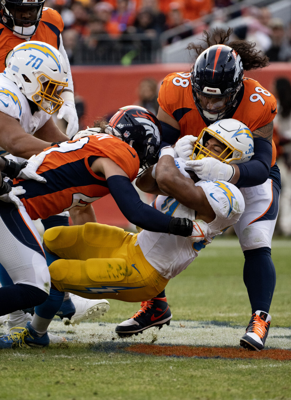 Los Angeles Chargers running back Austin Ekeler (30) is tackled by Denver Broncos defensive tackle Mike Purcell (98) and Denver Broncos linebacker Alex Singleton (49) in the first half of a game on Sunday, Nov. 26, 2023, at Empower Field at Mile High in Denver, Colo. (Parker Seibold, The Gazette) (Parker Seibold)