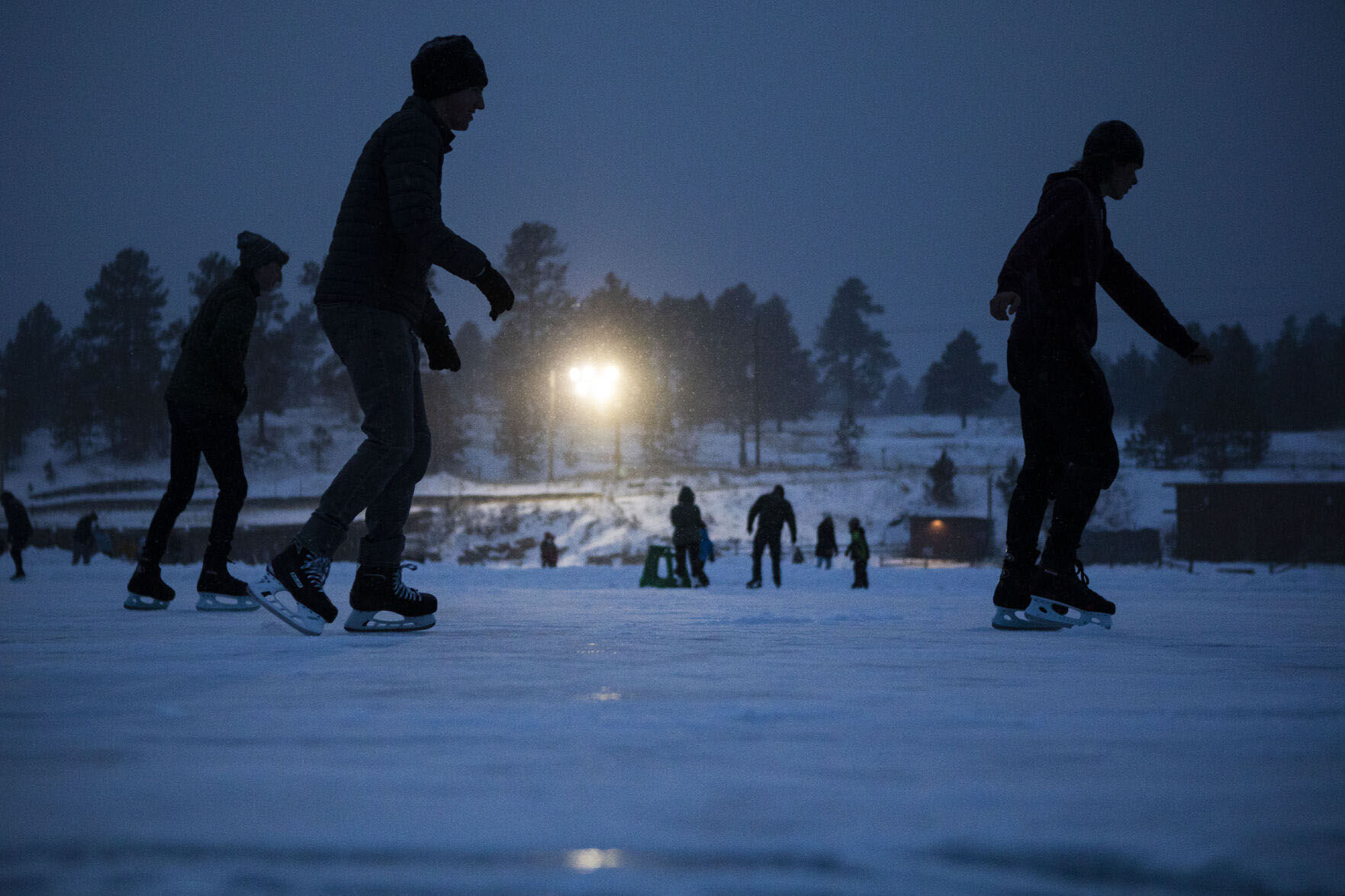 People do laps around the large rink on Evergreen Lake on Wednesday Jan. 5, in Evergreen. (The Gazette, Tim Hurst)