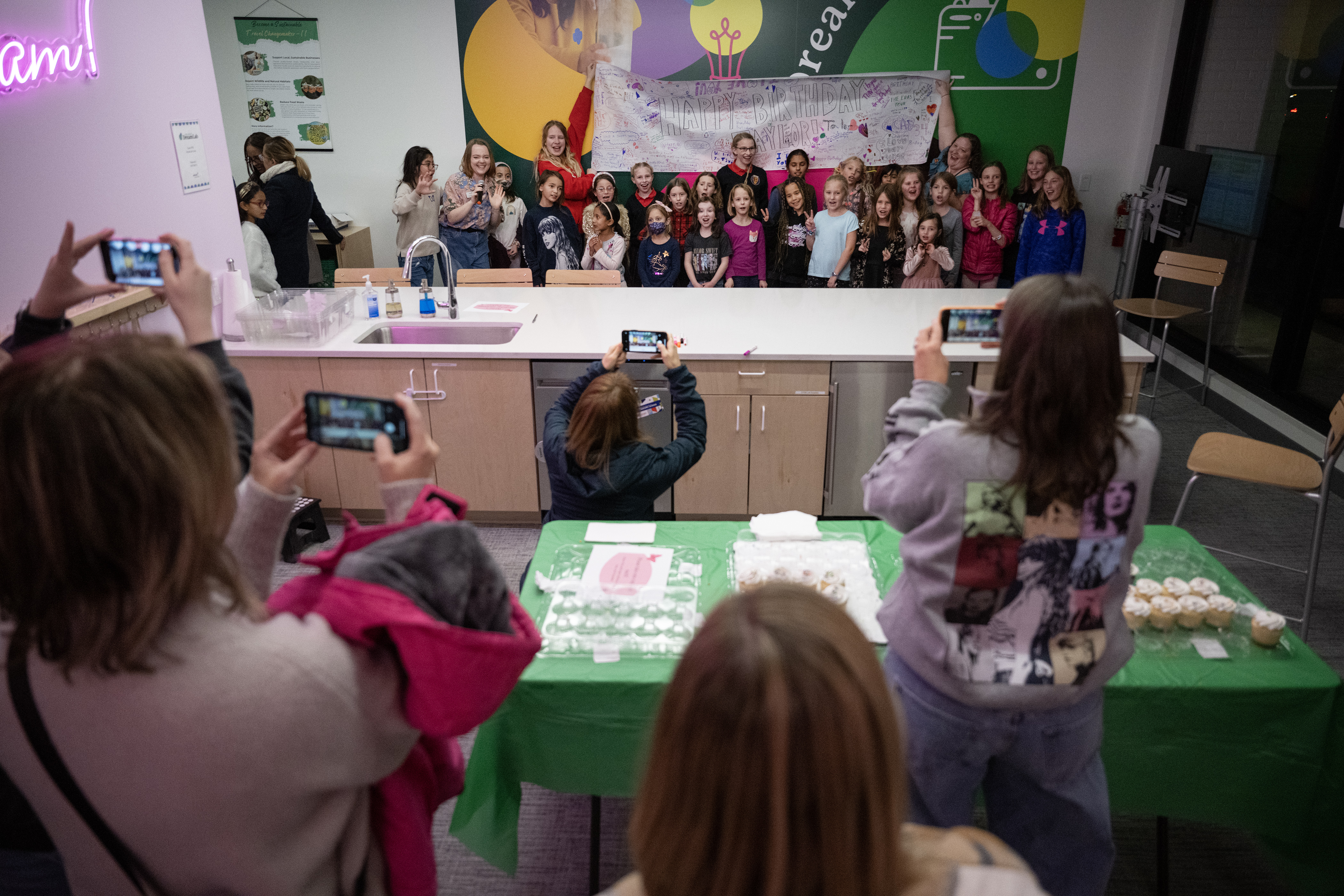Parents grab photos of party-goers holding up the giant birthday card they decorated during the “Mom and Me Swiftie Party!” to celebrate artist Taylor Swift’s birthday, on Tuesday, Dec. 12, 2023, at the Girl Scouts of Colorado DreamLab in Denver, Colo. (Timothy Hurst/Denver Gazette) (TimHursttim.hurst@gazette.comhttps://secure.gravatar.com/avatar/aca82bd62b4ee425c598527cd6faa1b1?d=mm&r=g)