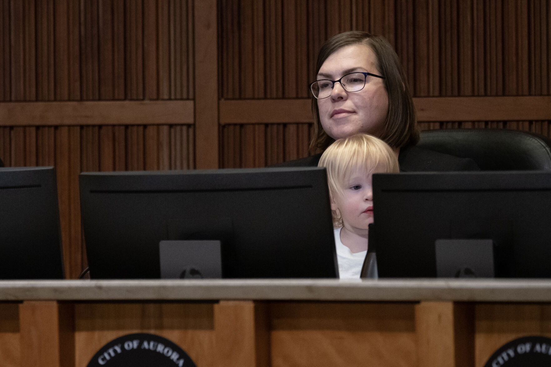 Aurora City Council member Alison Coombs holds her one-year old son Ellis while looking on from behind the dias during public comment during an Aurora City Council meeting on Monday, Dec. 4, 2023, at the Aurora Municipal Center in Aurora, Colo. (Timothy Hurst/Denver Gazette) (TimHursttim.hurst@gazette.comhttps://secure.gravatar.com/avatar/aca82bd62b4ee425c598527cd6faa1b1?d=mm&r=g)