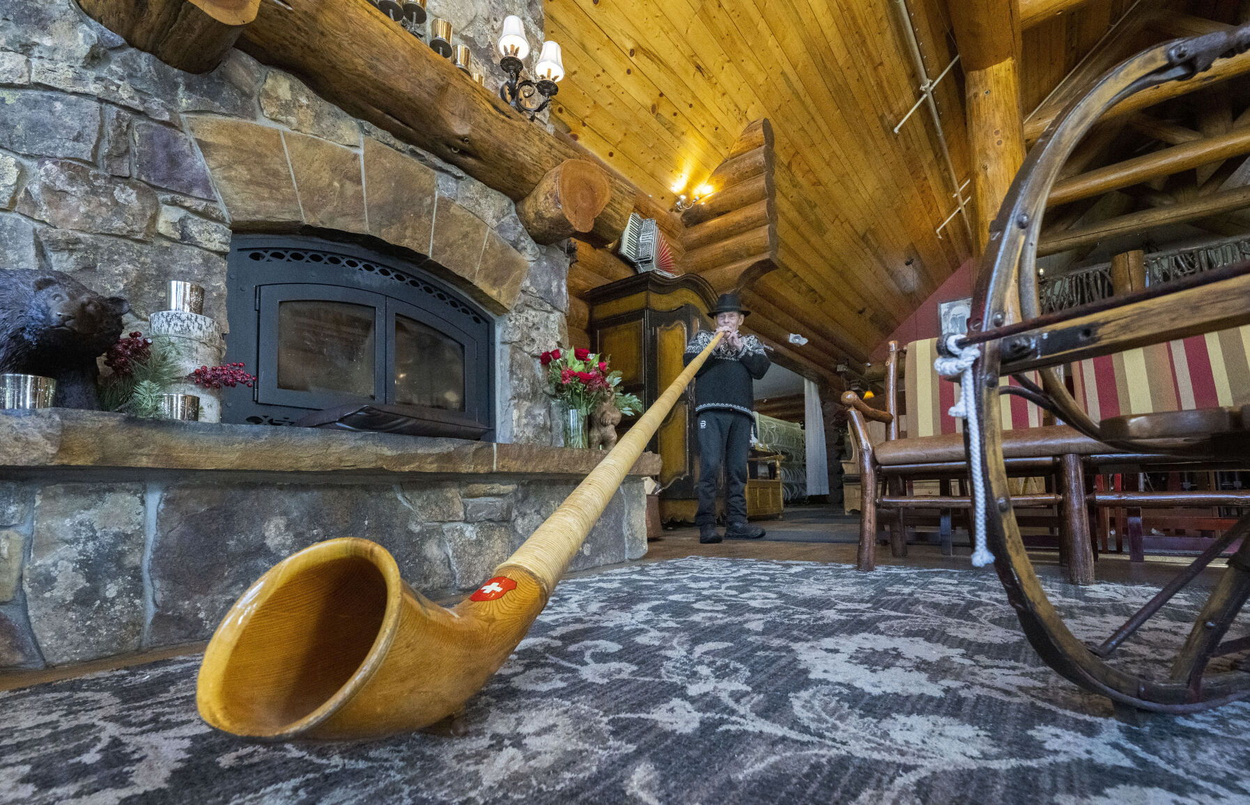Breckenridge Nordic Center founder and owner Gene Dayton plays the alphorn next to the fireplace Thursday, Nov. 30, 2023, in the Oh, be Joyful Lodge. The new lodge opened Christmas Day of 2013. (Christian Murdock, The Gazette)