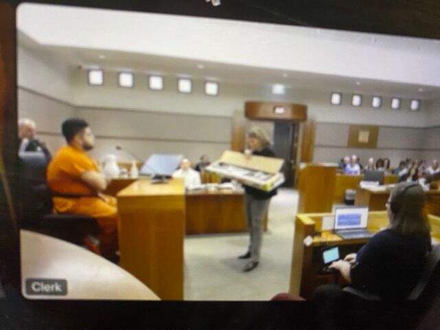 Jerry Lopez testified that an AR-15 being shown to him by First Judicial District Chief Prosecutor Brenna Zortman belongs to him. The trial of his brother-in-law, Sonny Almanza, is in its fourth day and expected to last into next week. (First Judicial District livestream via WebEx)
