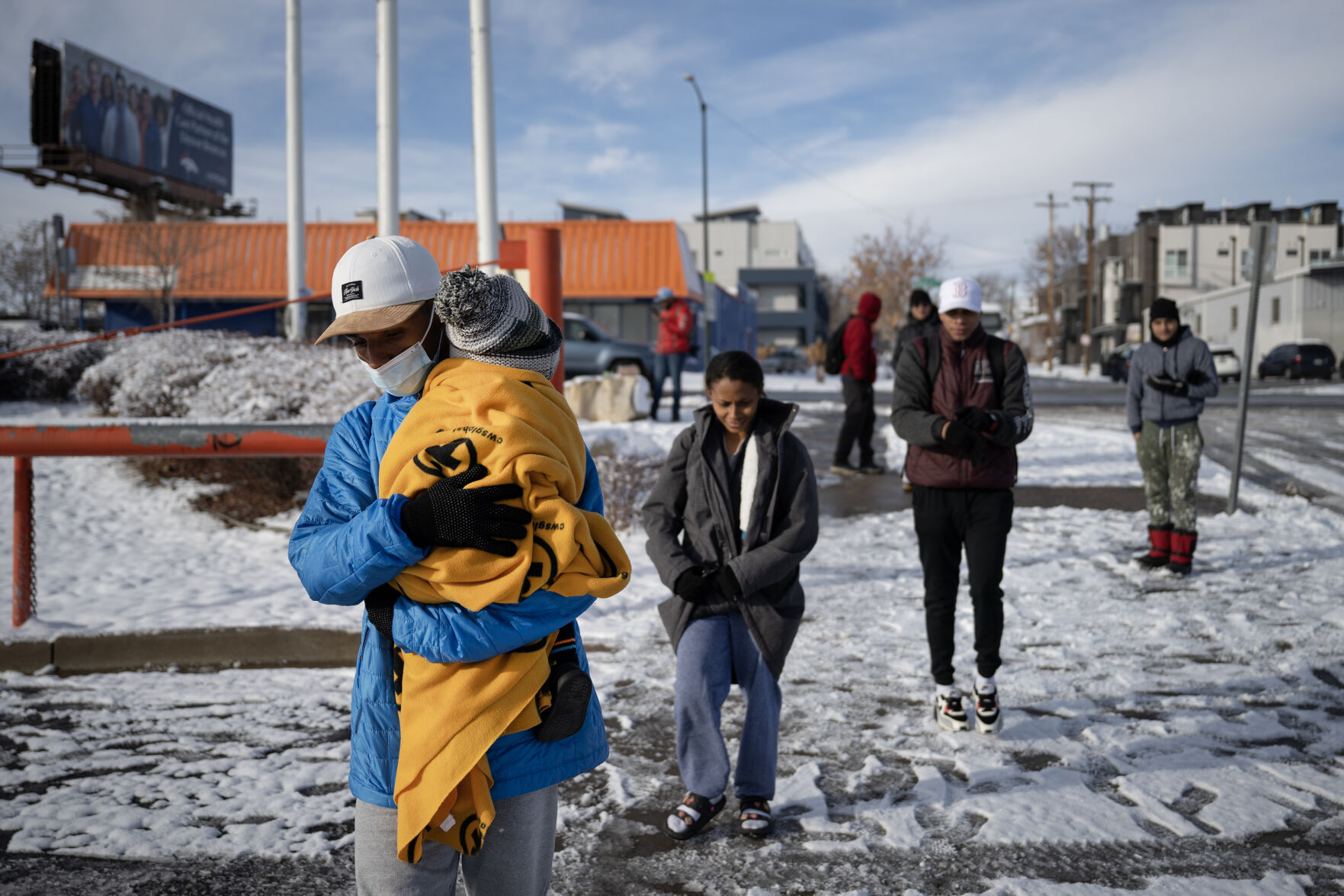 Newly arrived immigrant Jean Carlos Llerena carries his 1-year-old son Jeansdes after and his partner, Ma’riussy Rosa’do, and another family of immigrants, were dropped off by a bus from El Paso, Texas, at the bus stop near Federal Boulevard and West 19th Avenue after an overnight snowstorm on Dec. 9, in Denver. (TimHursttim.hurst@gazette.comhttps://secure.gravatar.com/avatar/aca82bd62b4ee425c598527cd6faa1b1?d=mm&r=g)