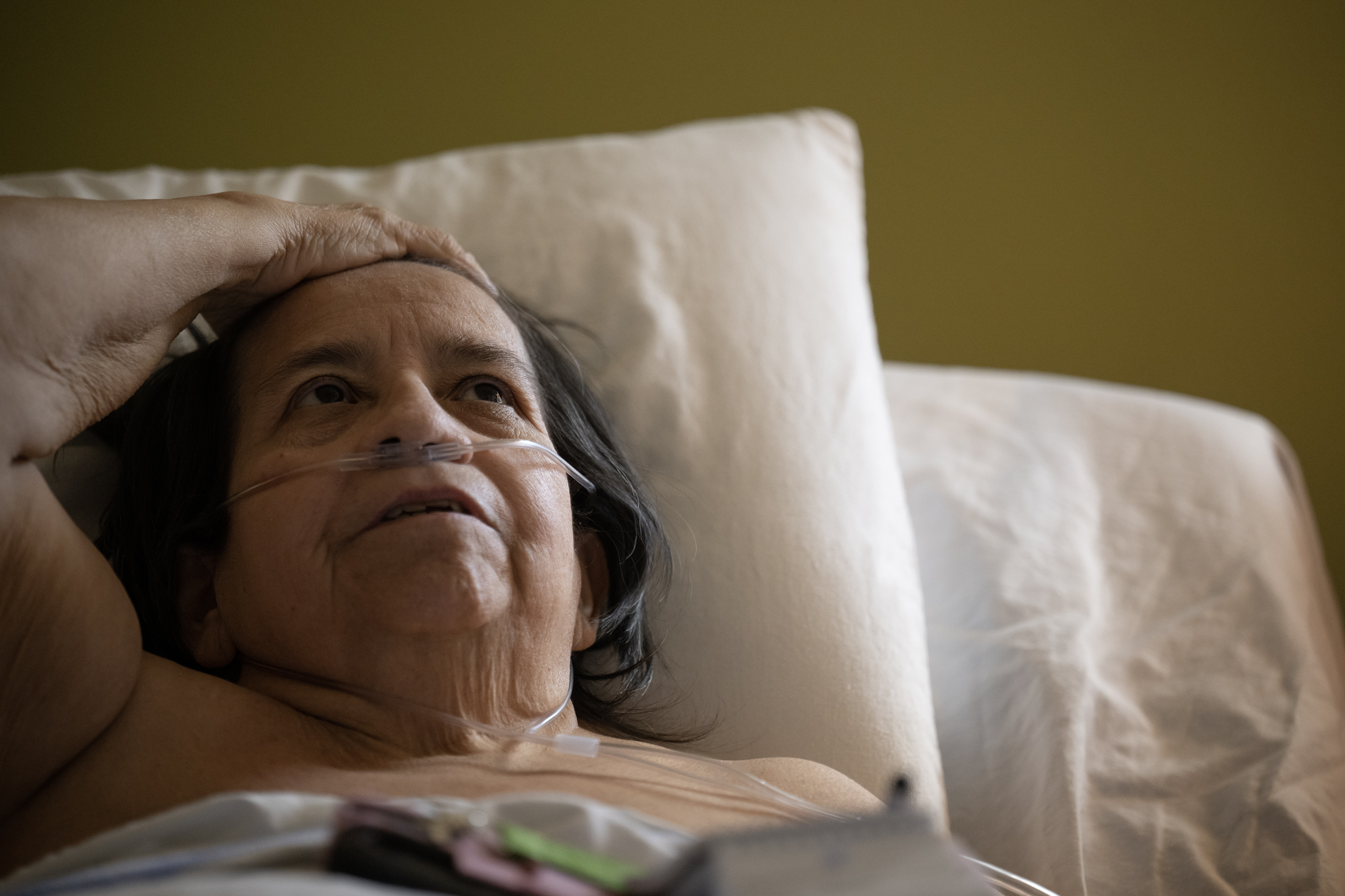 Louise Apodaca, bedridden due to multiple health issues, combs her hair back with her hand while discussing the stresses of organizing her own in-home care while at her apartment in a Denver Housing Authority high rise on Thursday, Nov. 16, 2023, in Denver, Colo. (Timothy Hurst/Denver Gazette) (TimHursttim.hurst@gazette.comhttps://secure.gravatar.com/avatar/aca82bd62b4ee425c598527cd6faa1b1?d=mm&r=g)