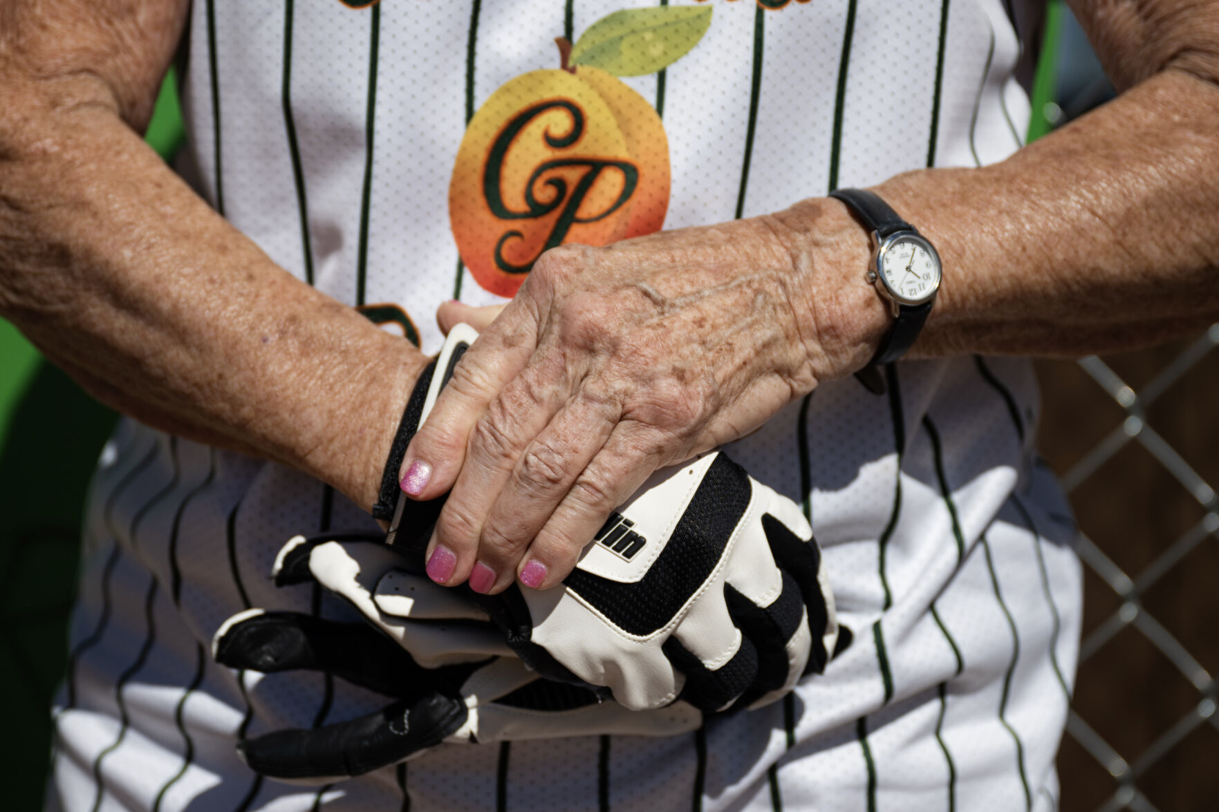 Colorado Peaches player Barbara “Mom” Johnson (24), playing for the Turnovers, straps on her batting loves before heading to the plate in a game against the Tarts during the Second Annual Gail Klock Memorial Peach Bowl on Tuesday, Aug. 29, 2023, at Addenbrooke Park in Lakewood, Colo. (Timothy Hurst/Denver Gazette) (TimHursttim.hurst@gazette.comhttps://secure.gravatar.com/avatar/aca82bd62b4ee425c598527cd6faa1b1?d=mm&r=g)