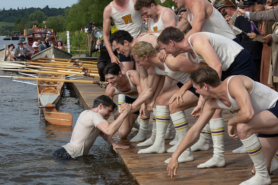 Denver's Luke Slattery, as coxswain Bobby Moch, is pulled out of the water by his pals during filming of director George Clooney’s 